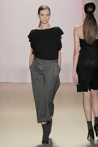 black ruffled top with gray pants