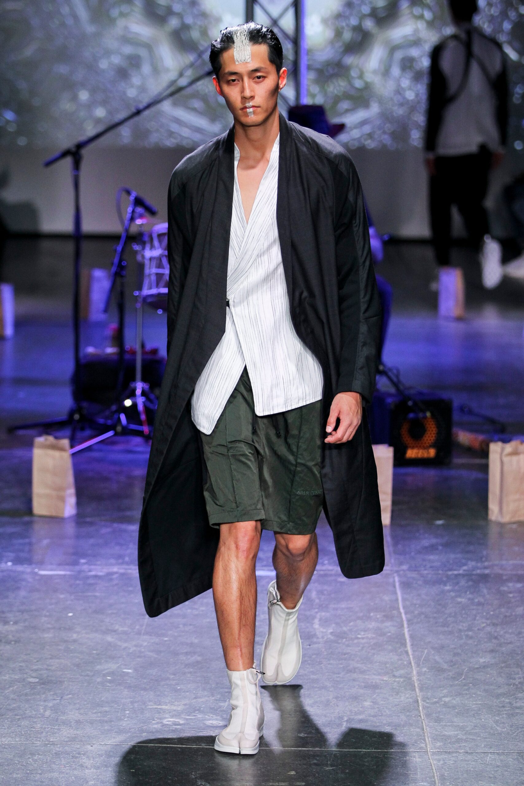 black coat white shirt green shorts