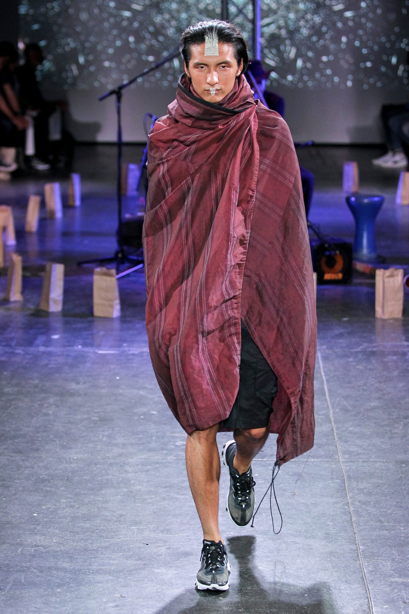 red silk draped cape with black shorts
