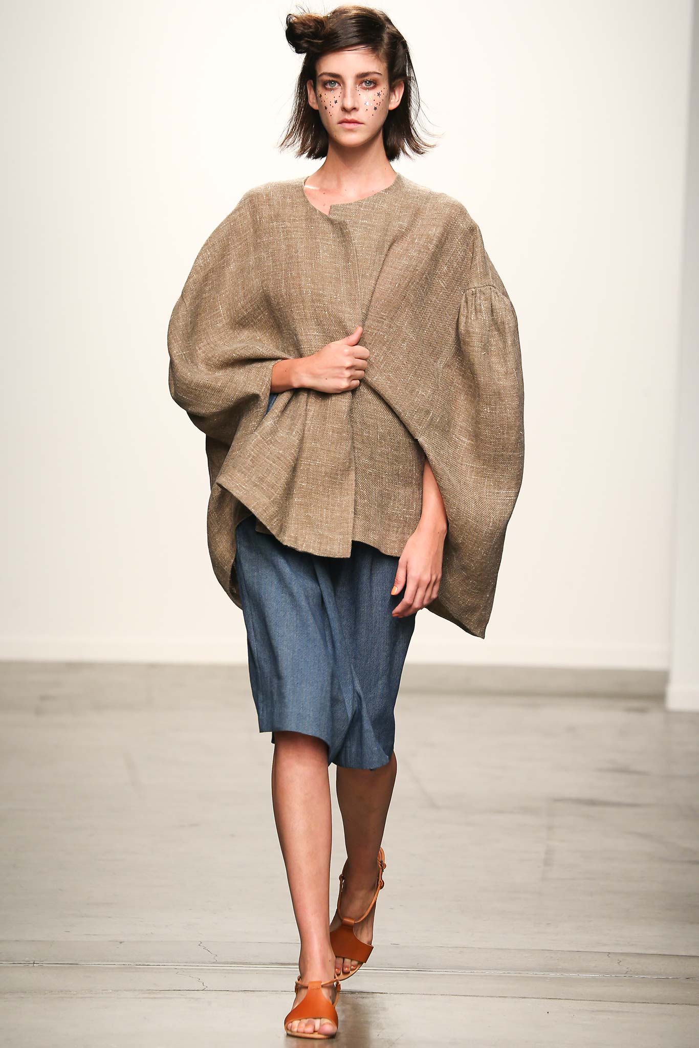A relaxed beige top with short sleeves and a collared design, paired with a blue skirt.