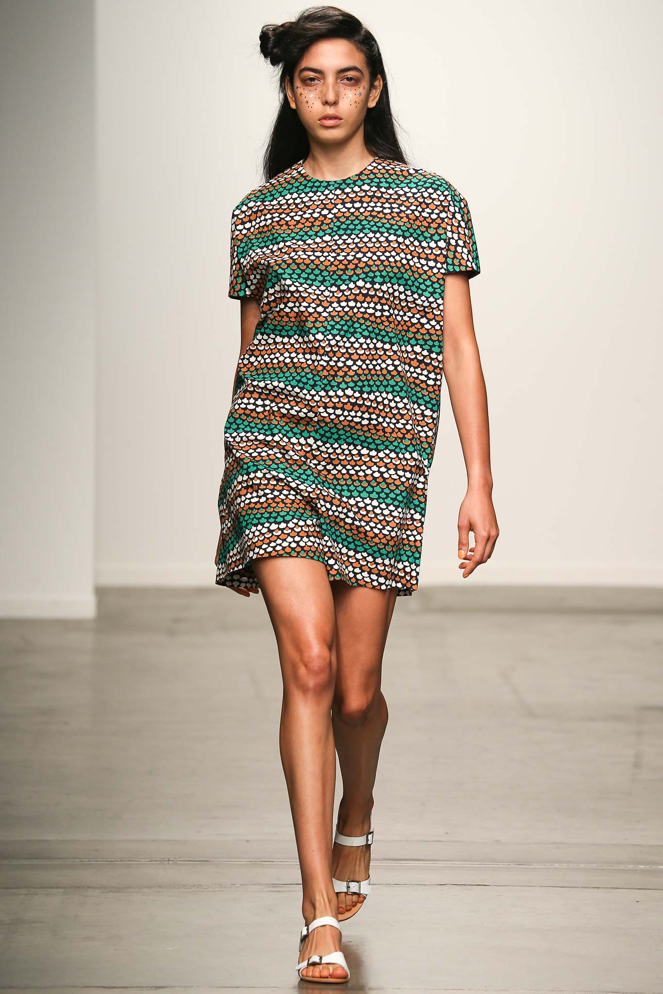 A relaxed short-sleeve dress with a colorful printed pattern in green, brown, and white.