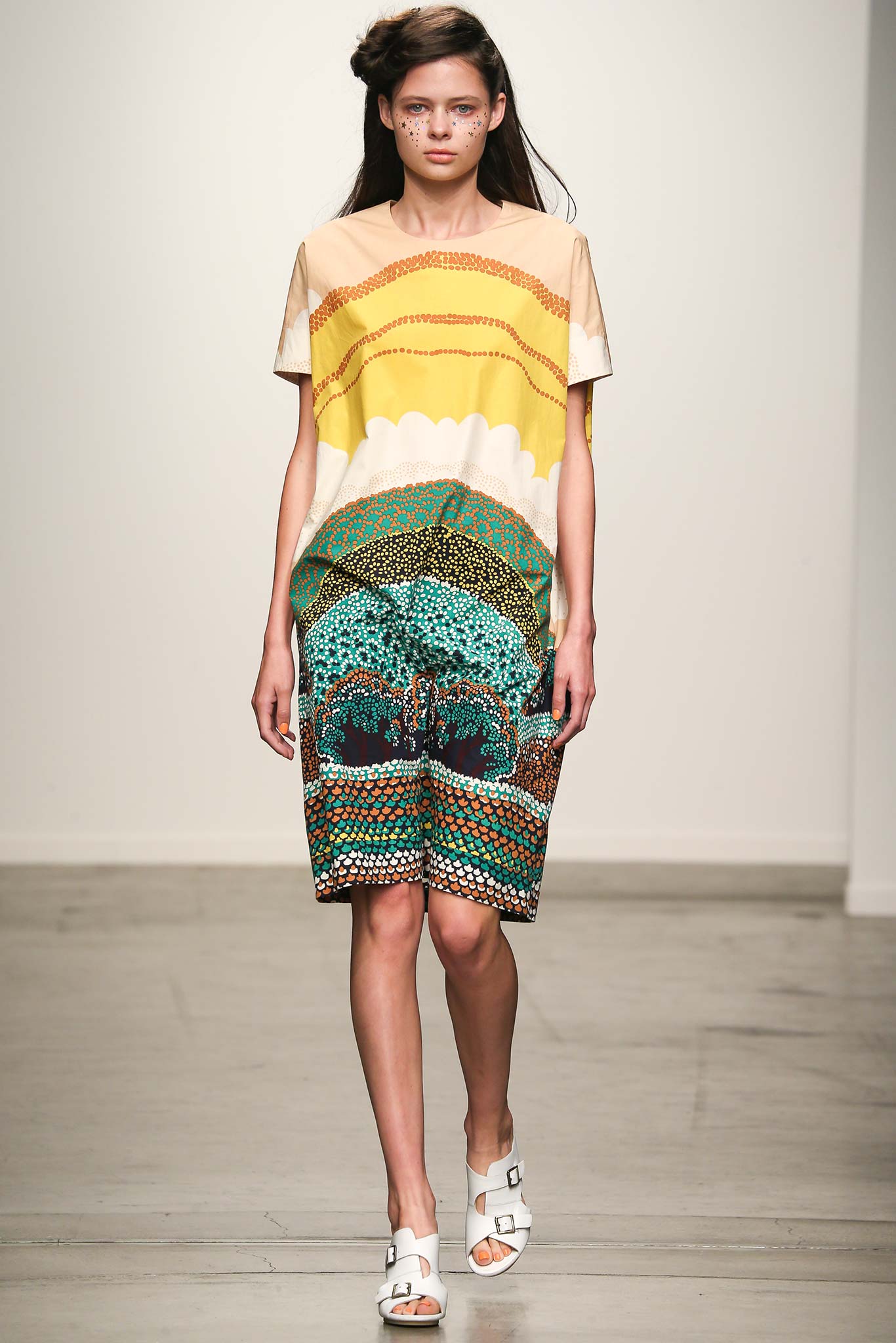 A relaxed short-sleeve dress featuring a vibrant printed design in yellow, green, and blue.