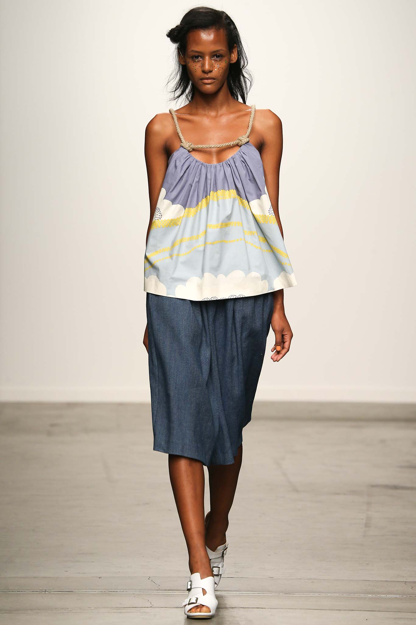 A relaxed blue printed sleeveless top with a collared design paired with an asymmetric skirt.