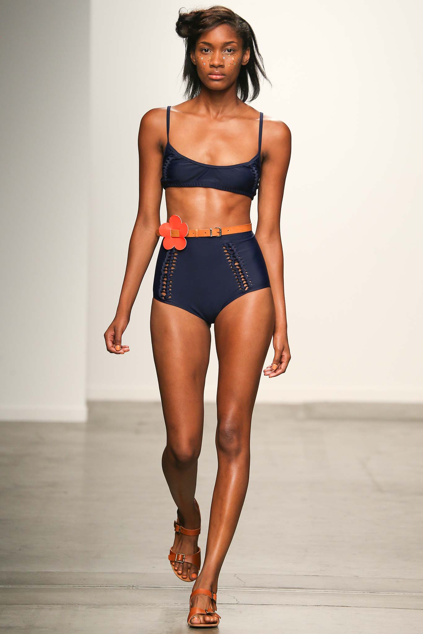 A fitted navy bikini paired with high-waisted shorts featuring a striped design.