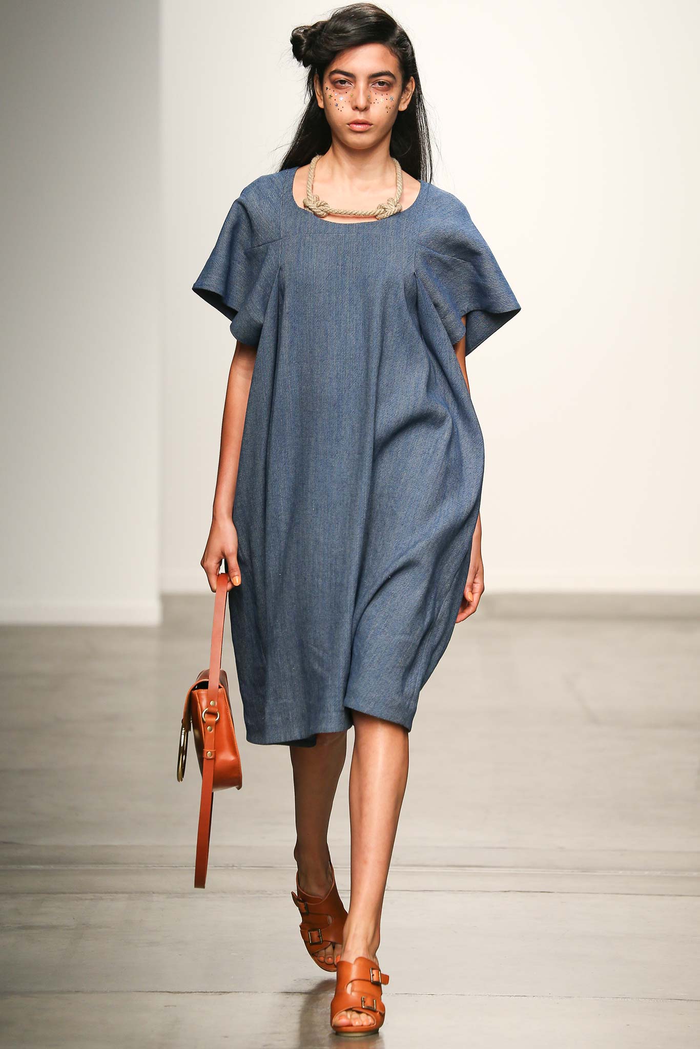 A relaxed blue denim dress with short sleeves and an A-line silhouette.