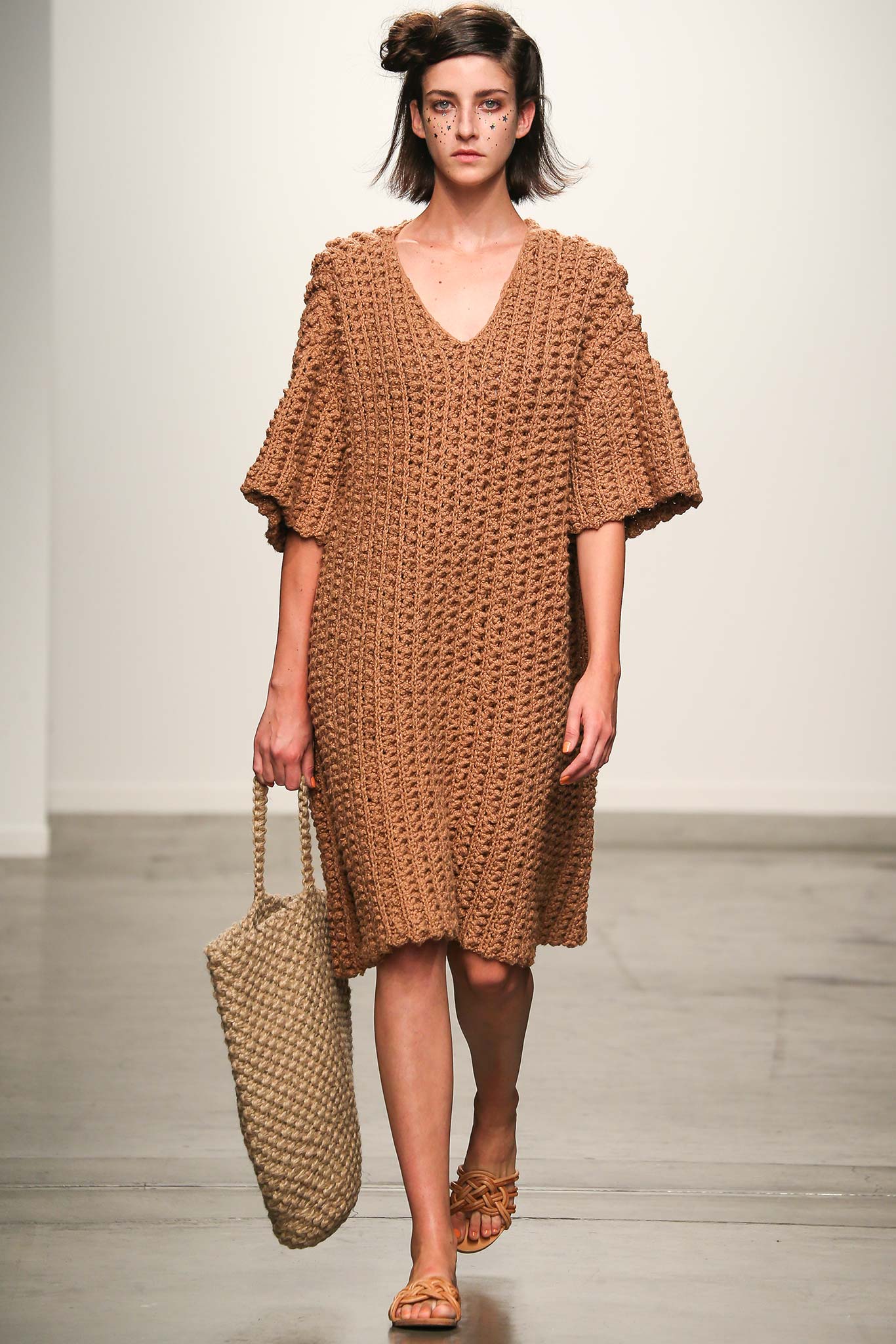 A relaxed brown crochet dress with a V-neckline and short sleeves.