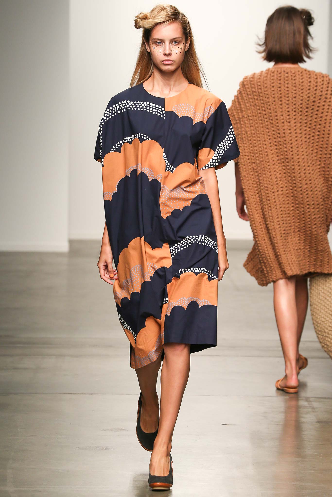A relaxed blue and orange printed dress with short sleeves and an asymmetric design.