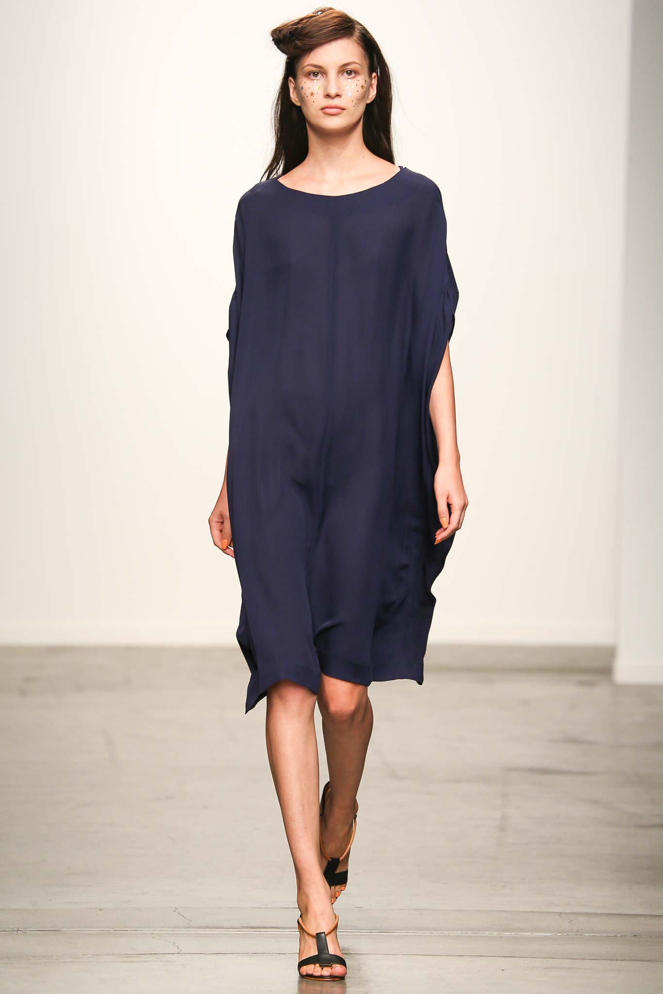 A relaxed blue silk sleeveless dress with a high neckline and asymmetric design.