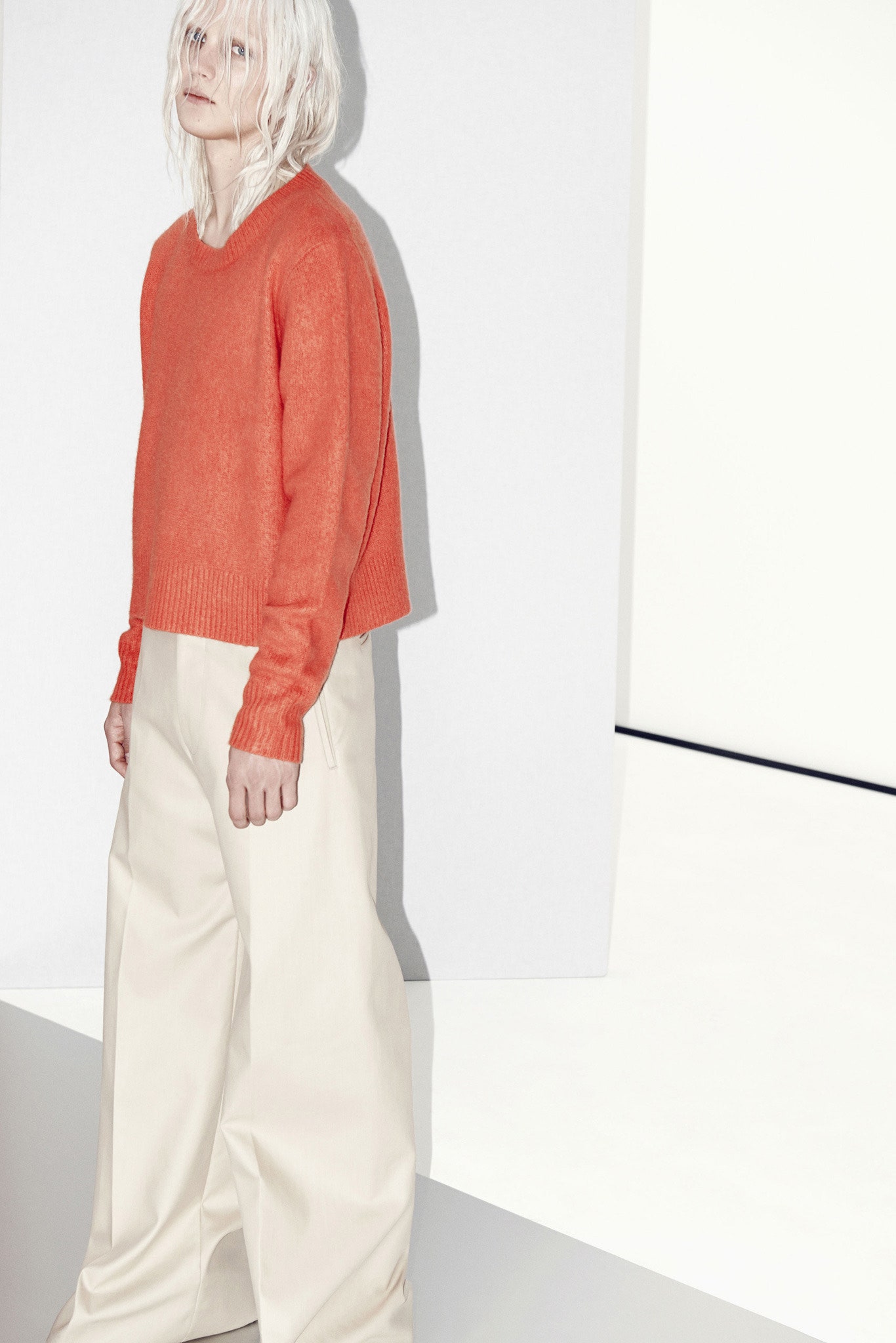 orange cropped sweater and beige wide-leg pants