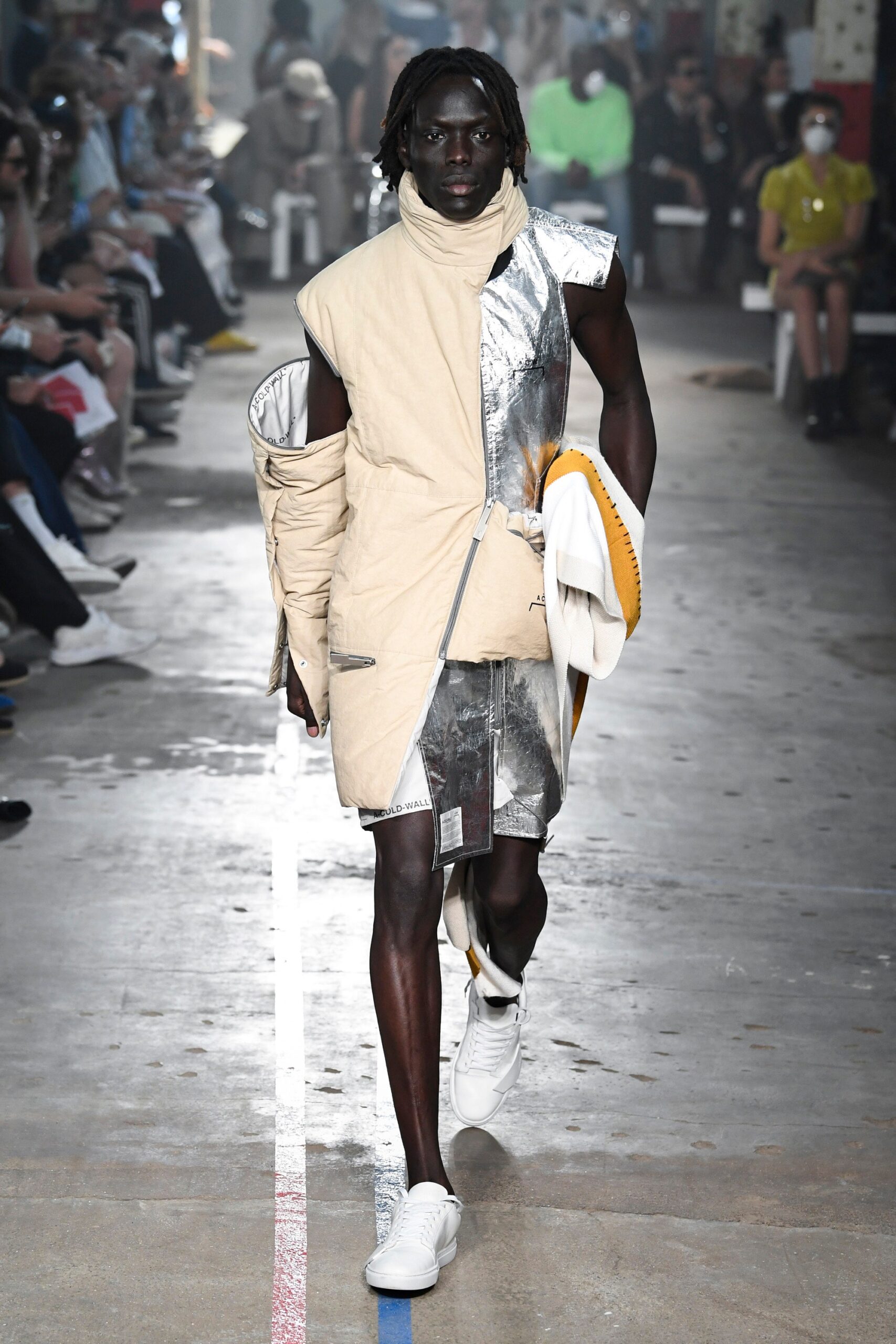 This relaxed dress features a unique asymmetric design, combining beige cotton with metallic accents for a striking visual contrast. The high-neck construction adds an element of sophistication, while the zippered detail enhances its modern appeal.