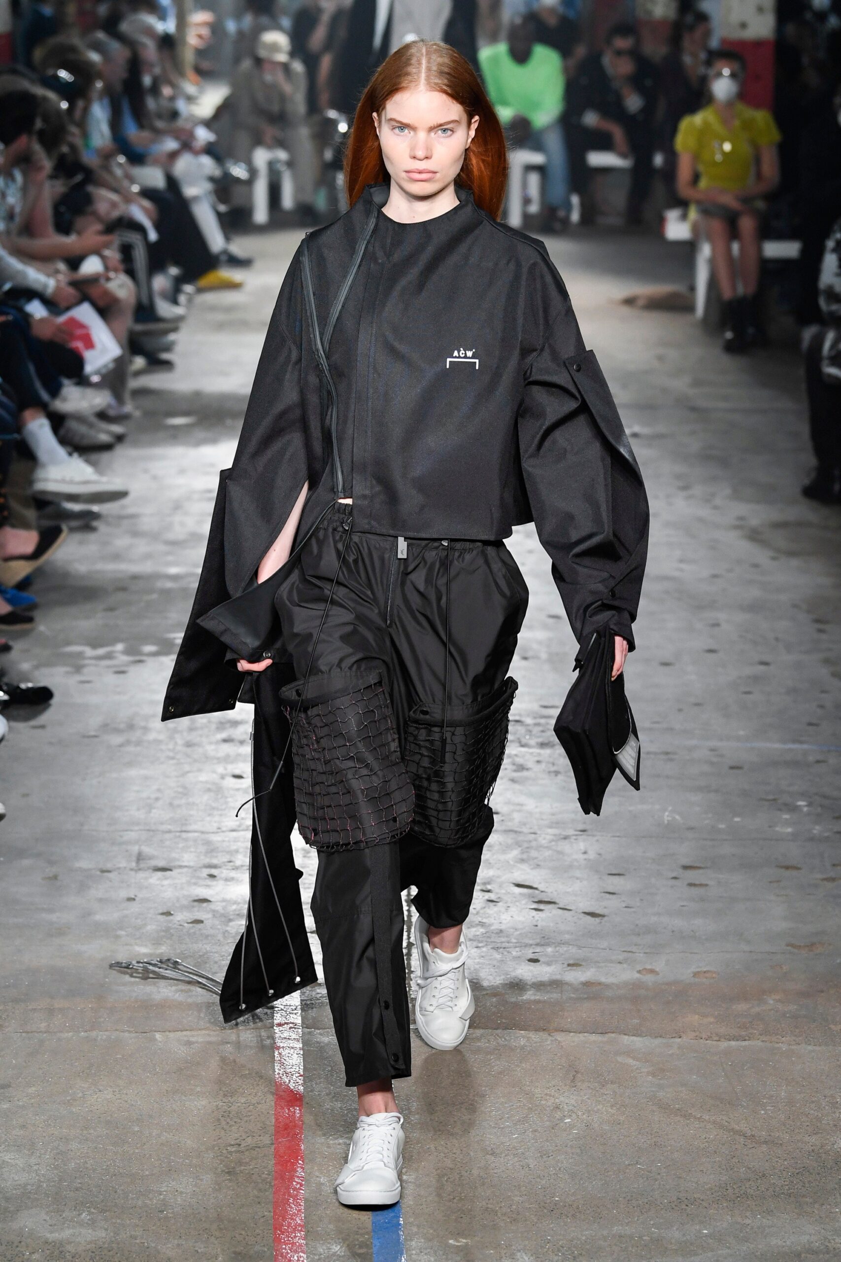 This ensemble features a relaxed black jacket with an asymmetric design, complemented by matching pants that offer a contemporary silhouette. The zippered details add an element of modernity, creating a striking visual impact that balances structure with fluidity.