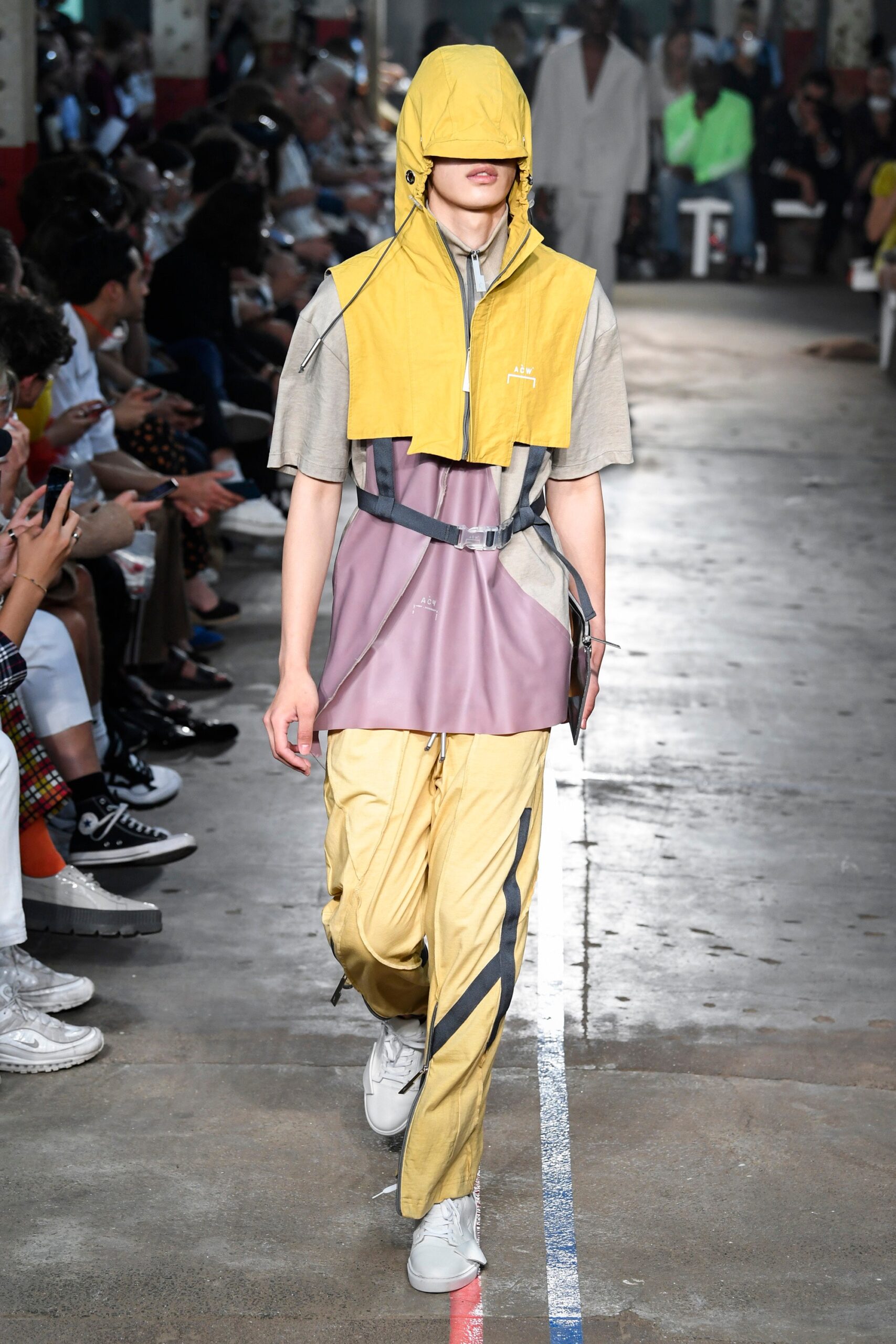 This relaxed ensemble features a short-sleeve hooded jacket in a striking color-blocked design, combining shades of yellow and gray. The asymmetric lines and casual fit create a dynamic silhouette that captures attention while maintaining an effortless vibe.