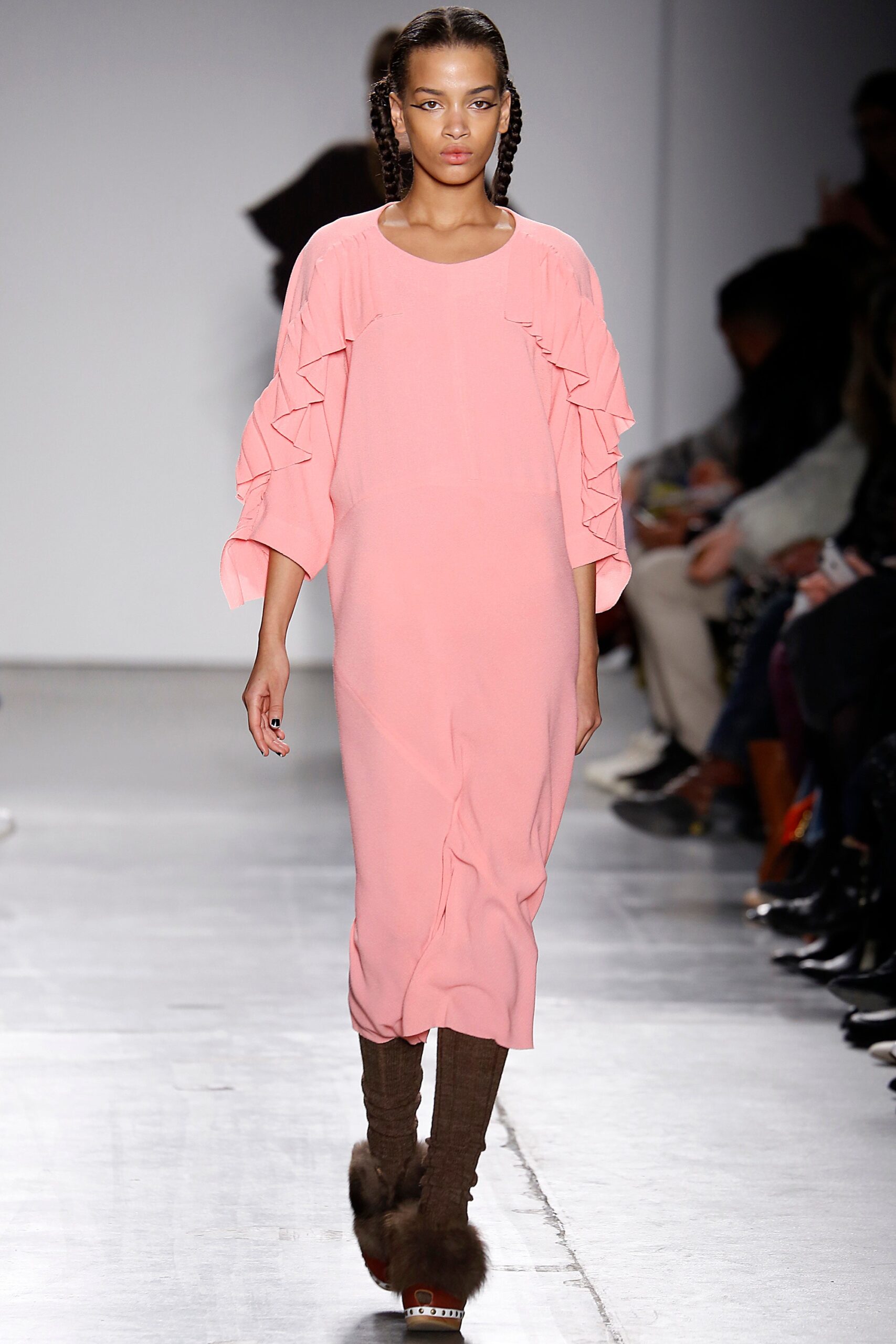 A relaxed pink dress with long sleeves and ruffled details.