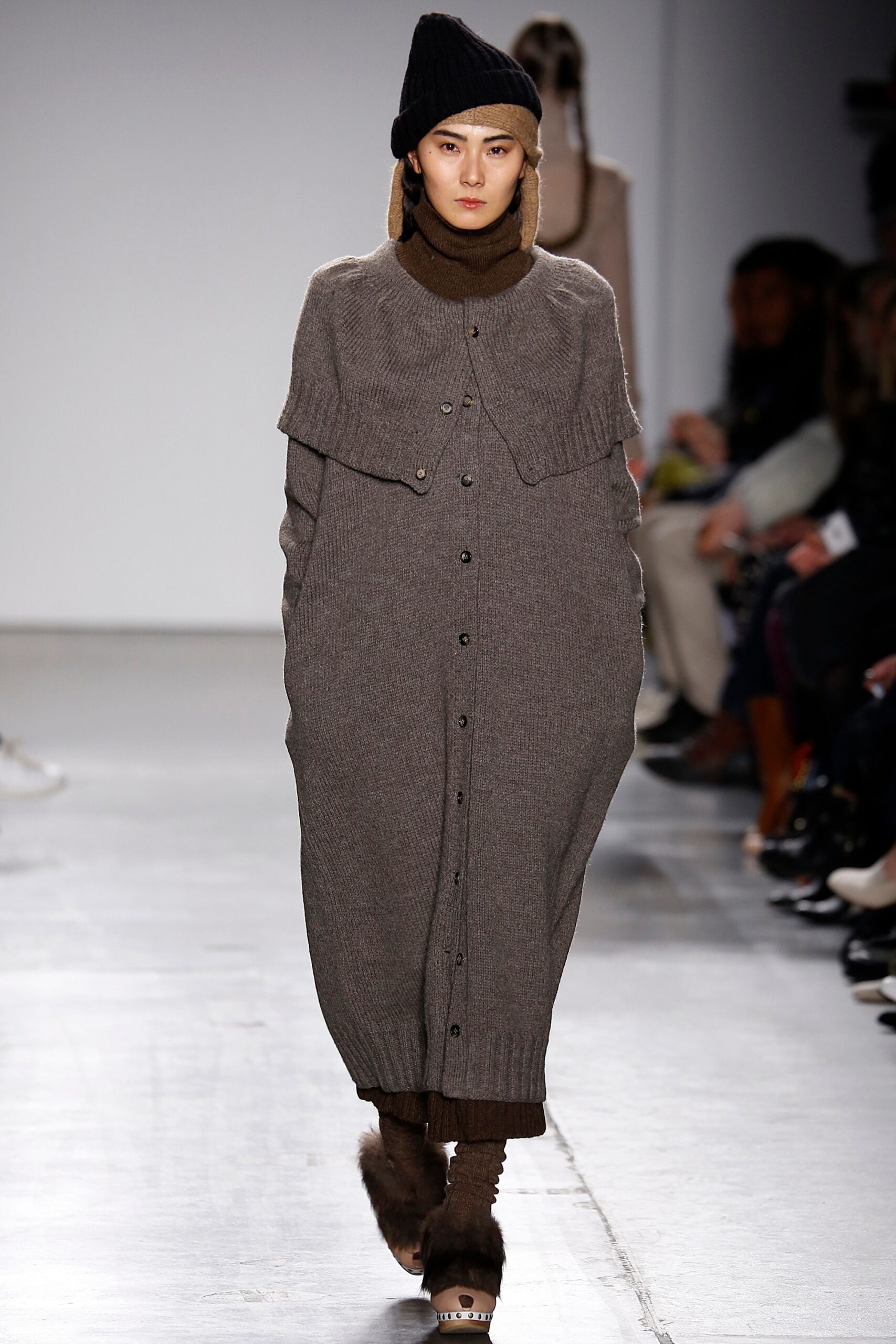 An oversized brown wool dress with long sleeves and a collared design featuring button details.