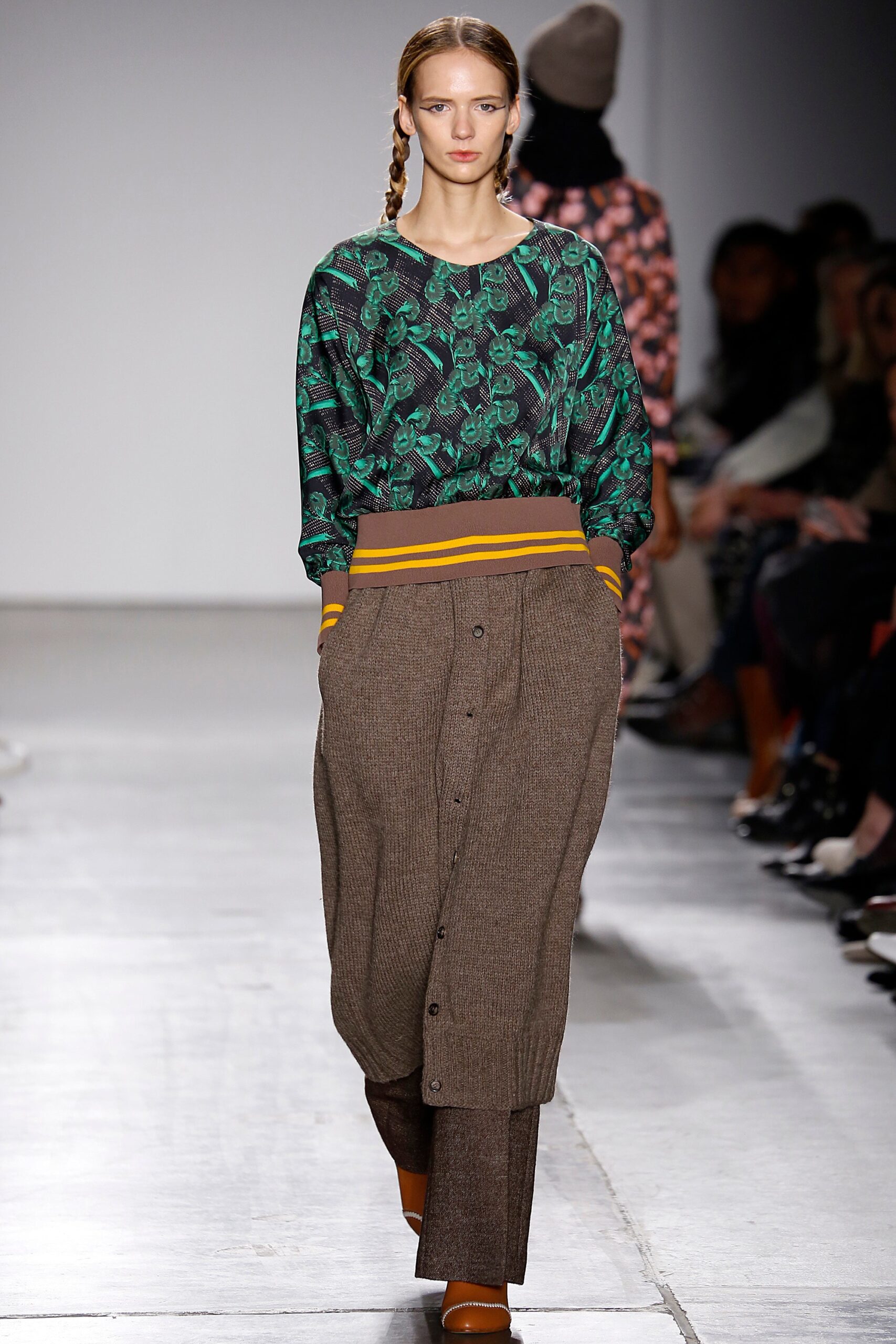 A relaxed fit green printed top with long sleeves paired with brown buttoned pants.