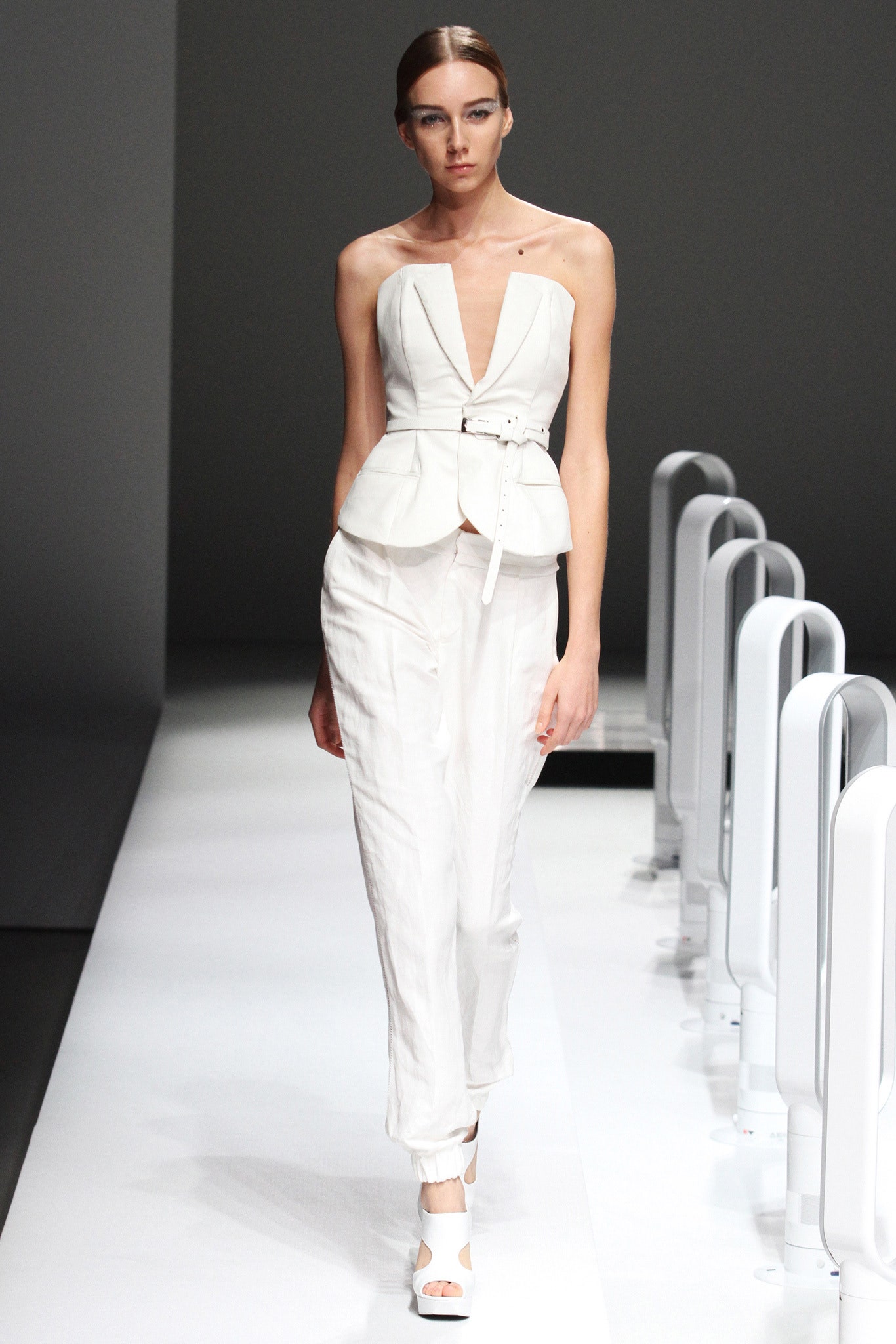 A fitted white sleeveless blazer with a V-neckline paired with matching pants.