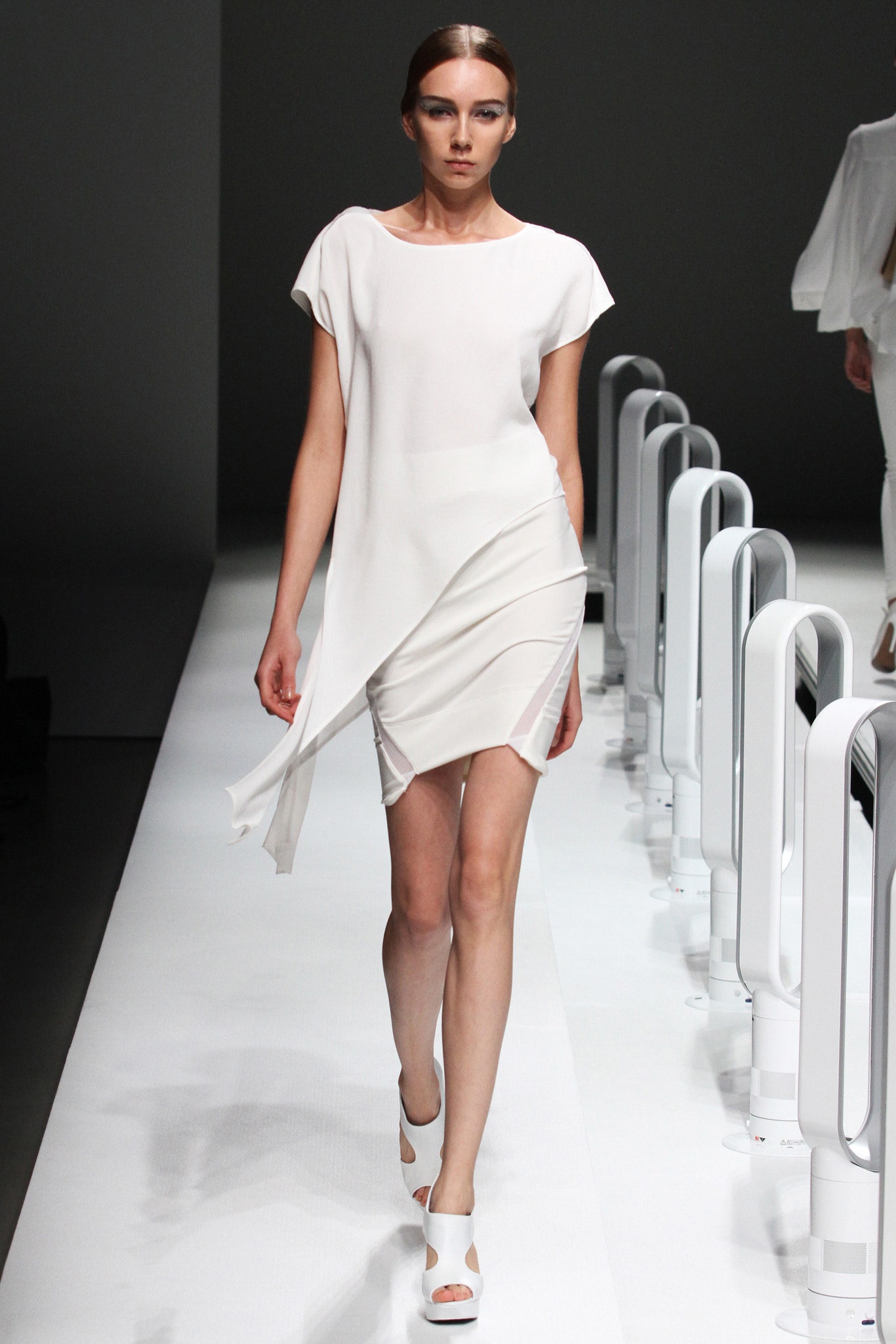 A fitted white silk dress with a sleeveless design and asymmetric detail.