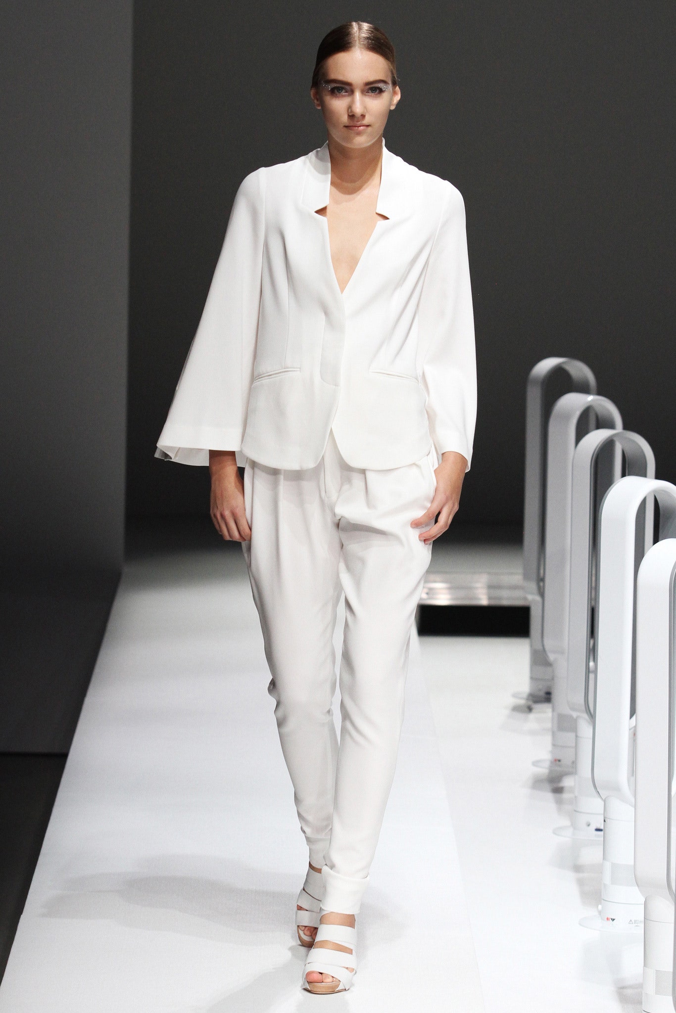 A fitted white blazer with a V-neckline paired with matching pants for a sleek look.