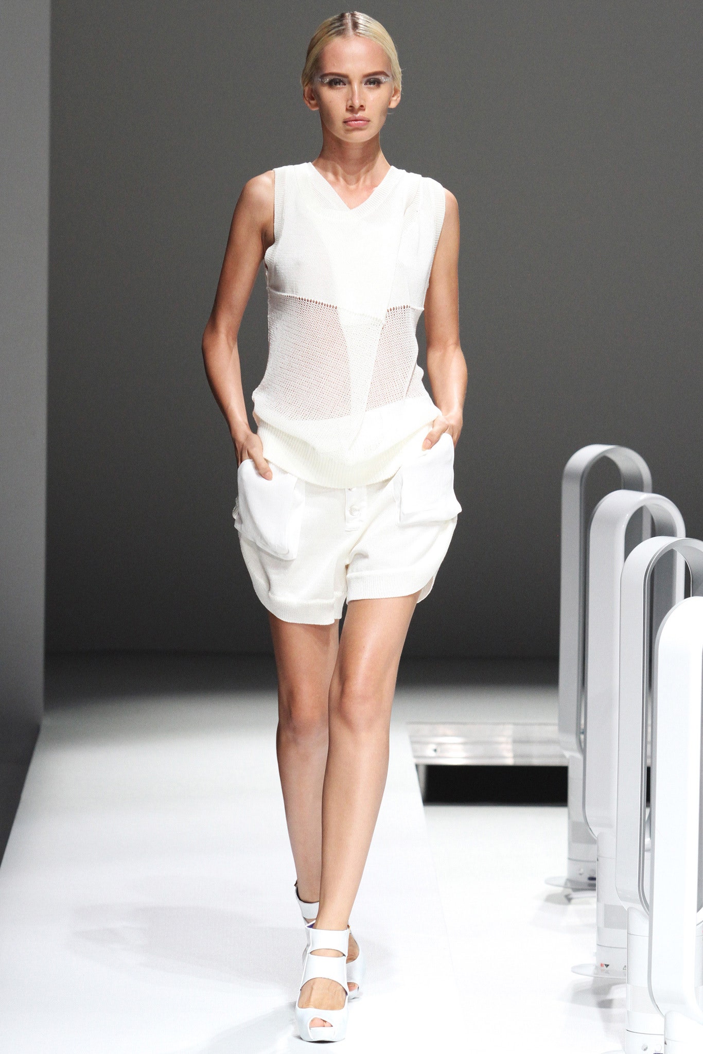 A fitted white sleeveless top paired with matching shorts featuring a layered design.