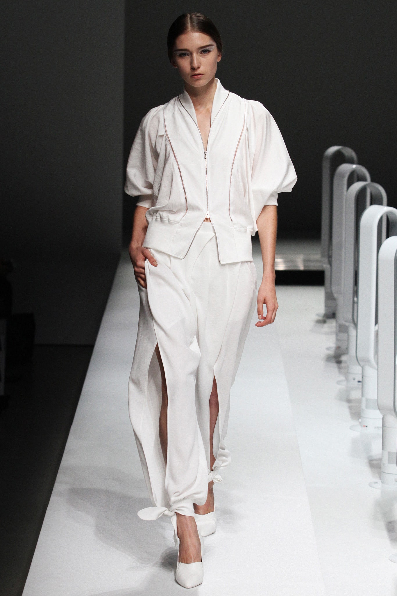 A relaxed white jacket with short sleeves and a collared neckline paired with wide-leg pants.