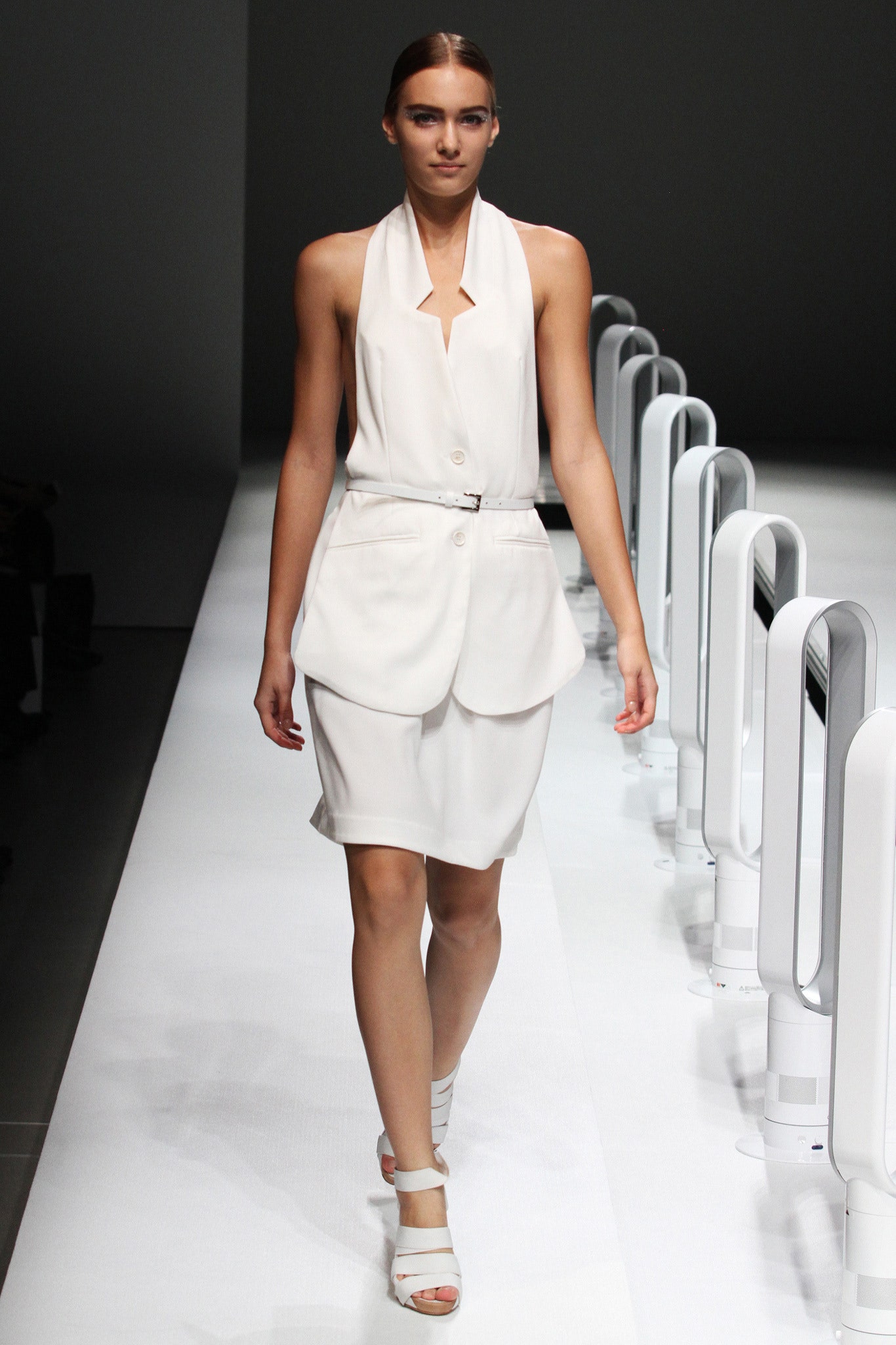 A fitted white sleeveless dress with a collared neckline and asymmetric design.