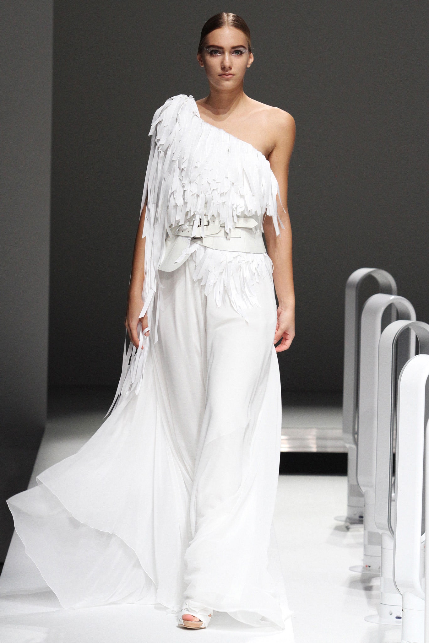 A relaxed white chiffon sleeveless dress with a high neckline and asymmetric fringed detailing.