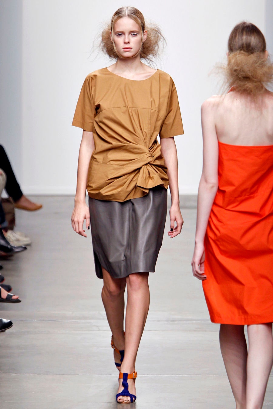 A fitted brown top with short sleeves and a high-waisted gray skirt featuring an asymmetric design.