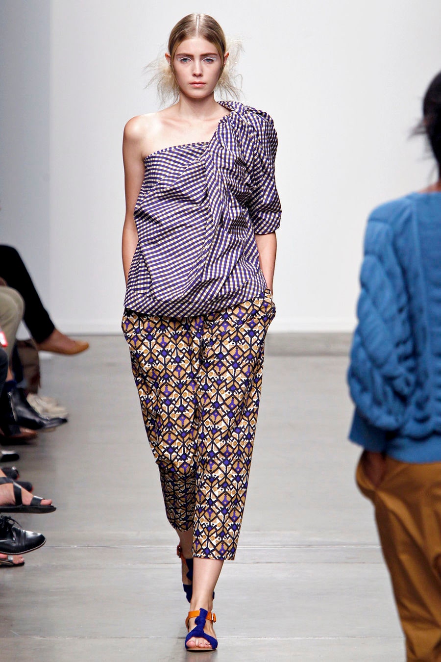 A relaxed purple printed off-shoulder top paired with patterned pants, showcasing a unique asymmetric design.