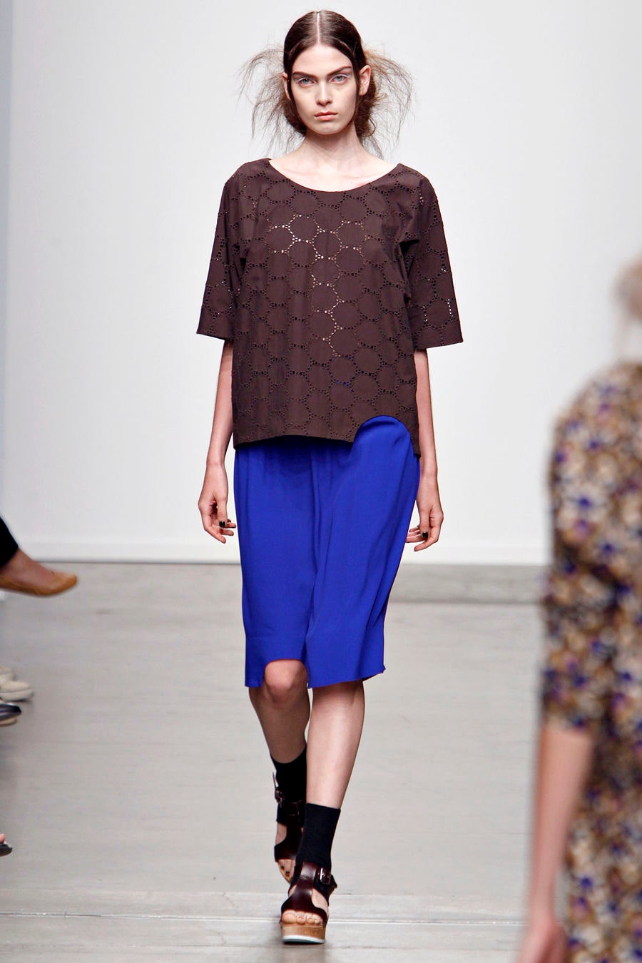 A relaxed black printed top paired with blue culottes, featuring short sleeves and a collared design.