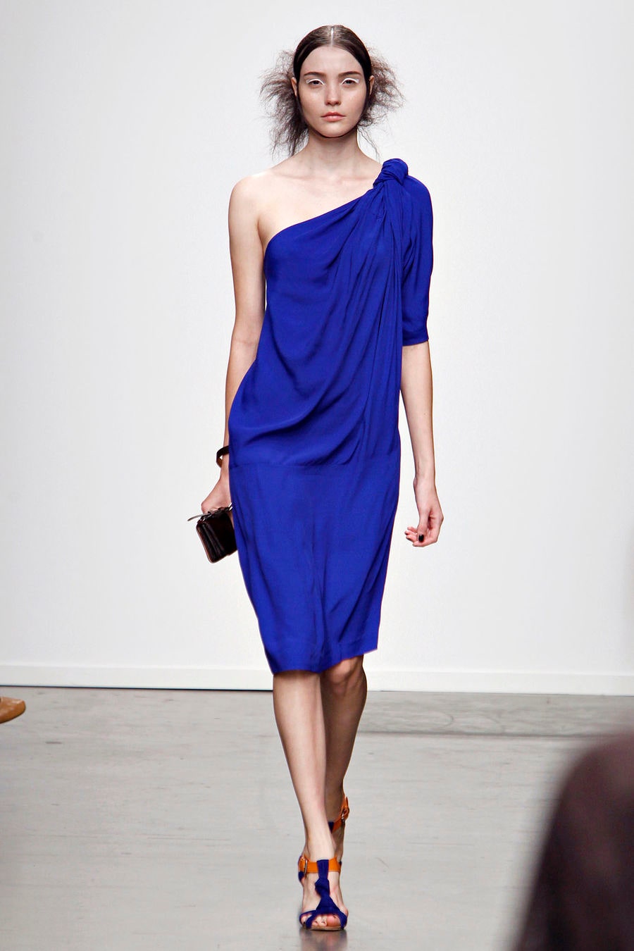 A relaxed blue silk dress with a one-shoulder design and draped detailing.