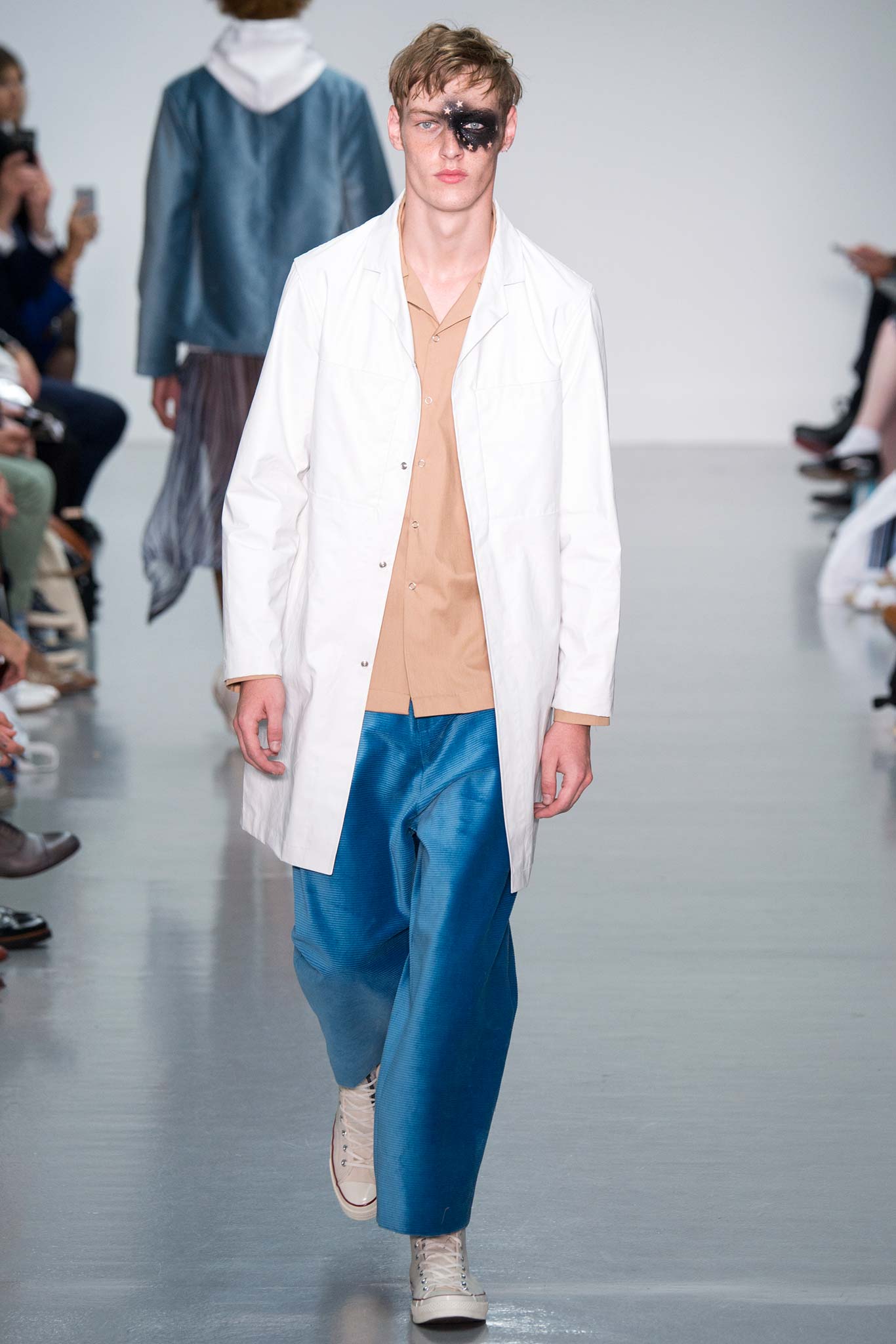 white coat beige shirt blue pants