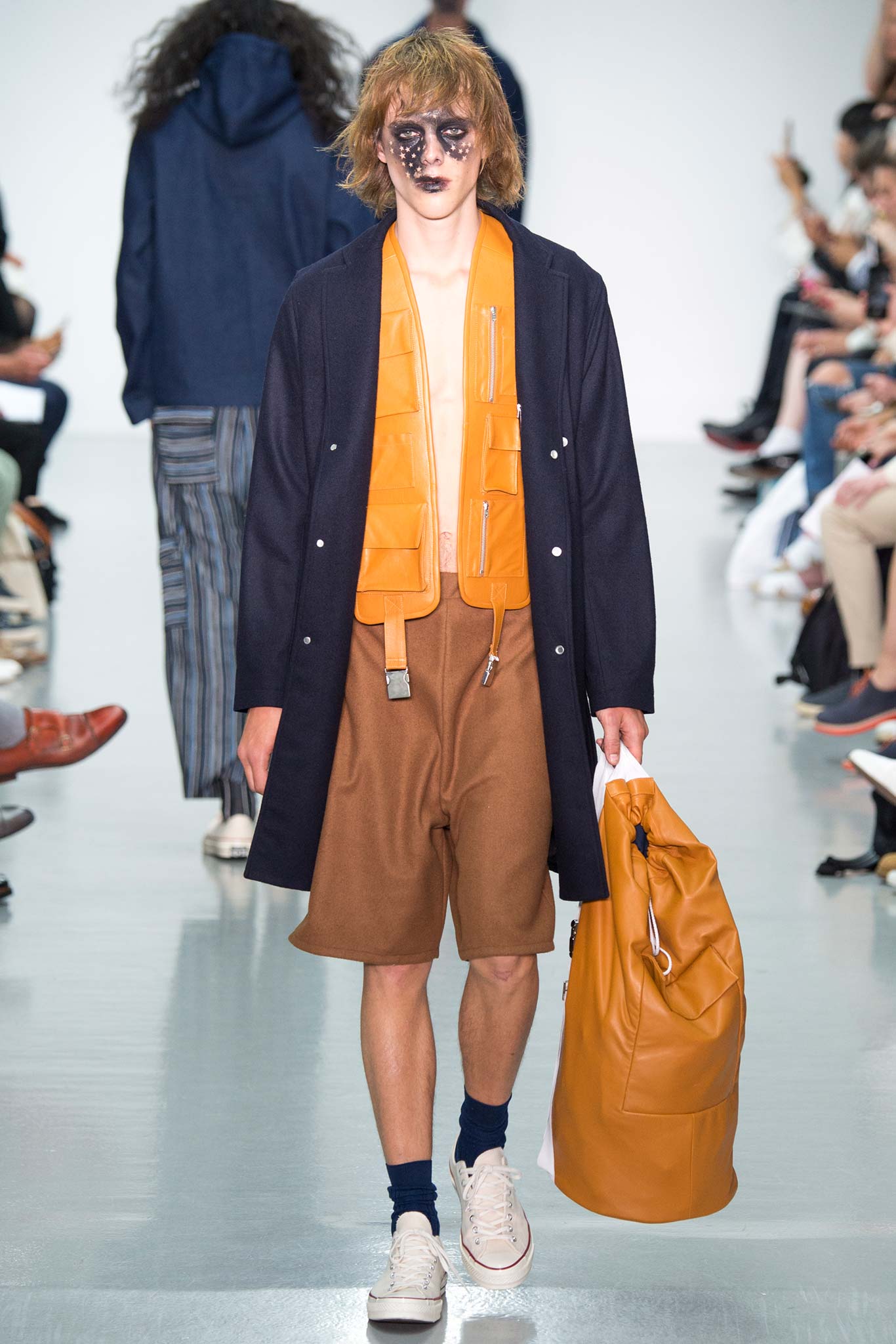 navy coat orange top brown shorts