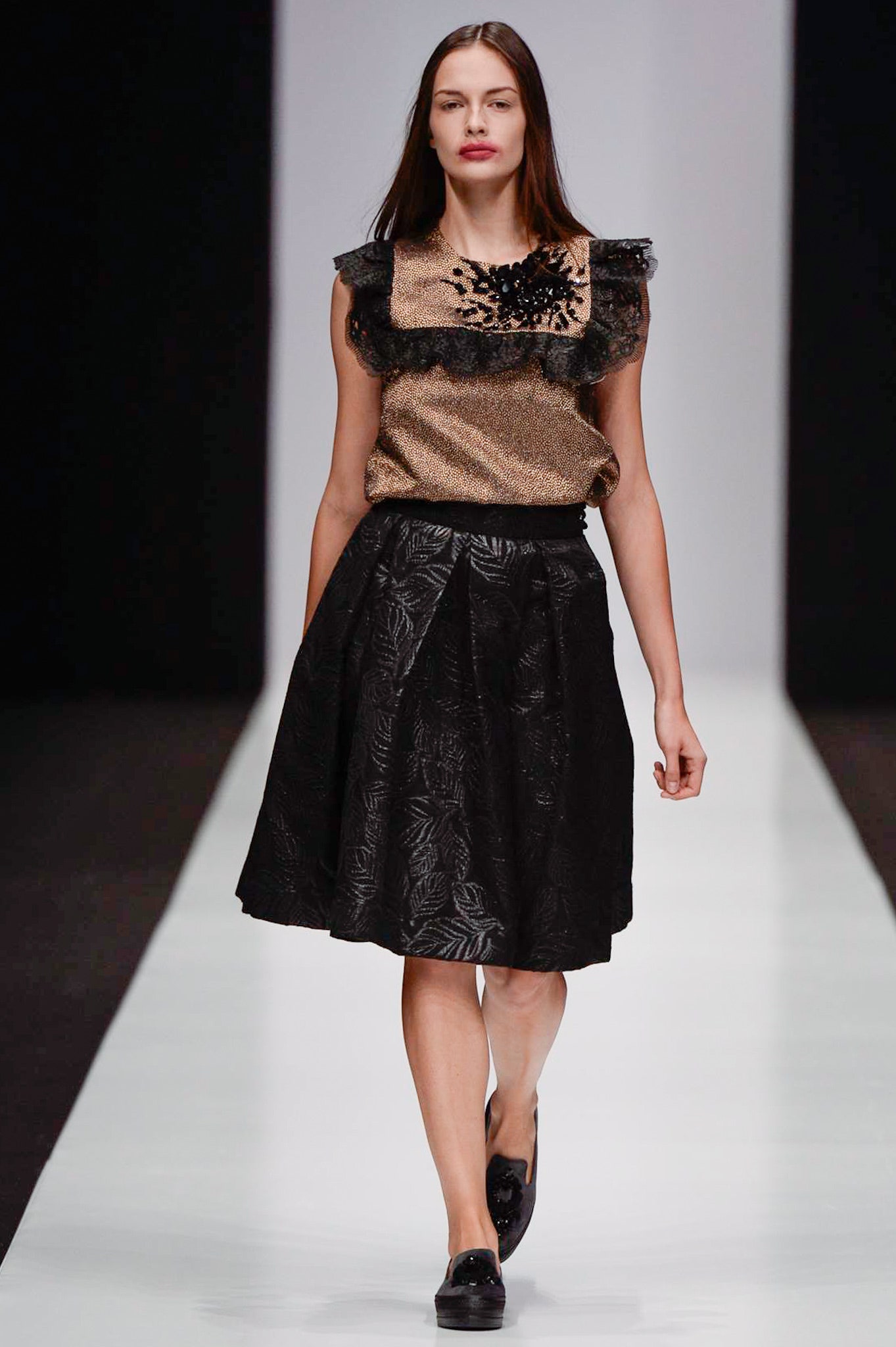 gold silk ruffled top and black pleated skirt