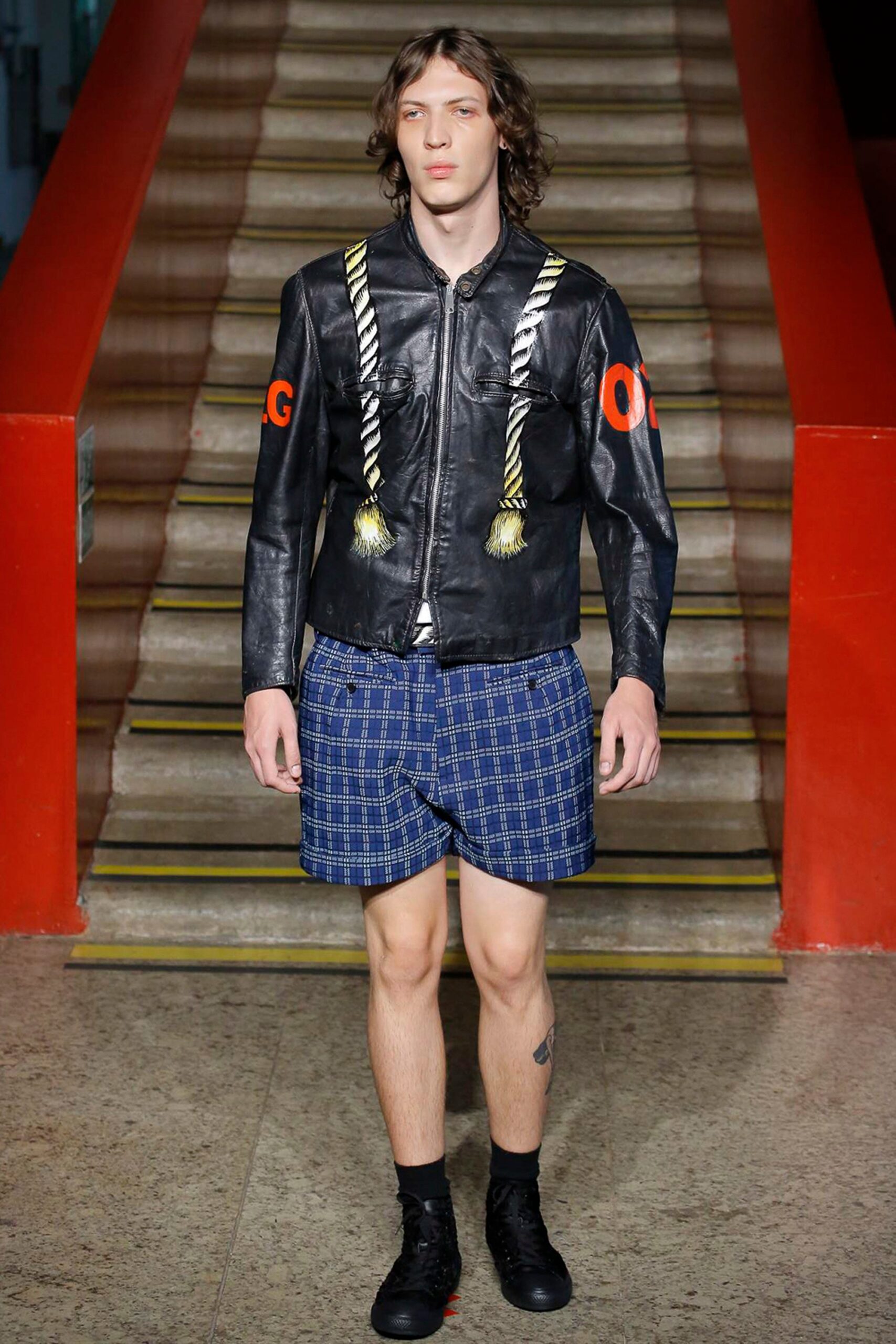 black leather fitted jacket and blue checked shorts