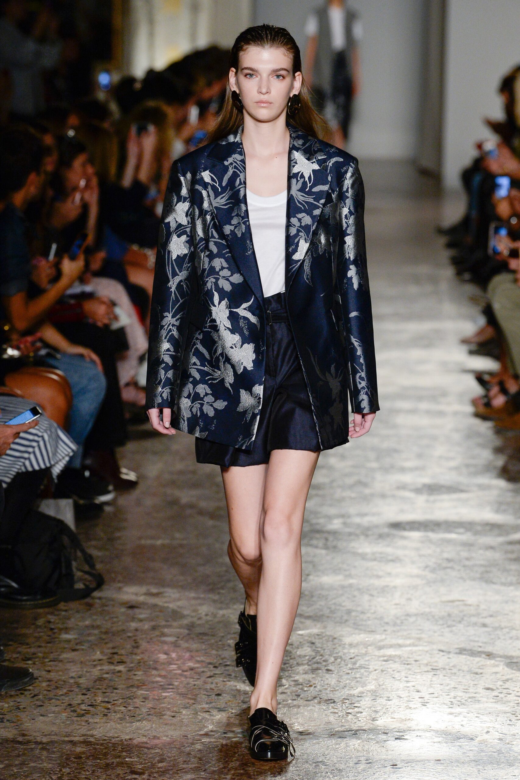 blue embroidered blazer with white top and black shorts