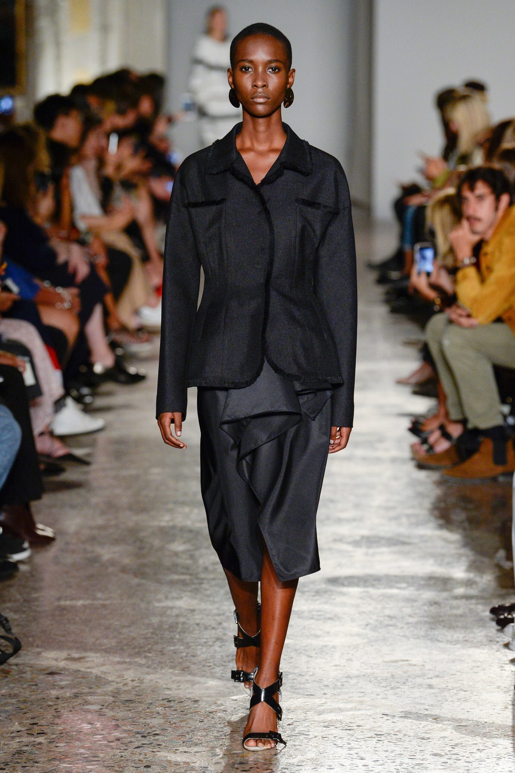 black structured jacket and draped skirt