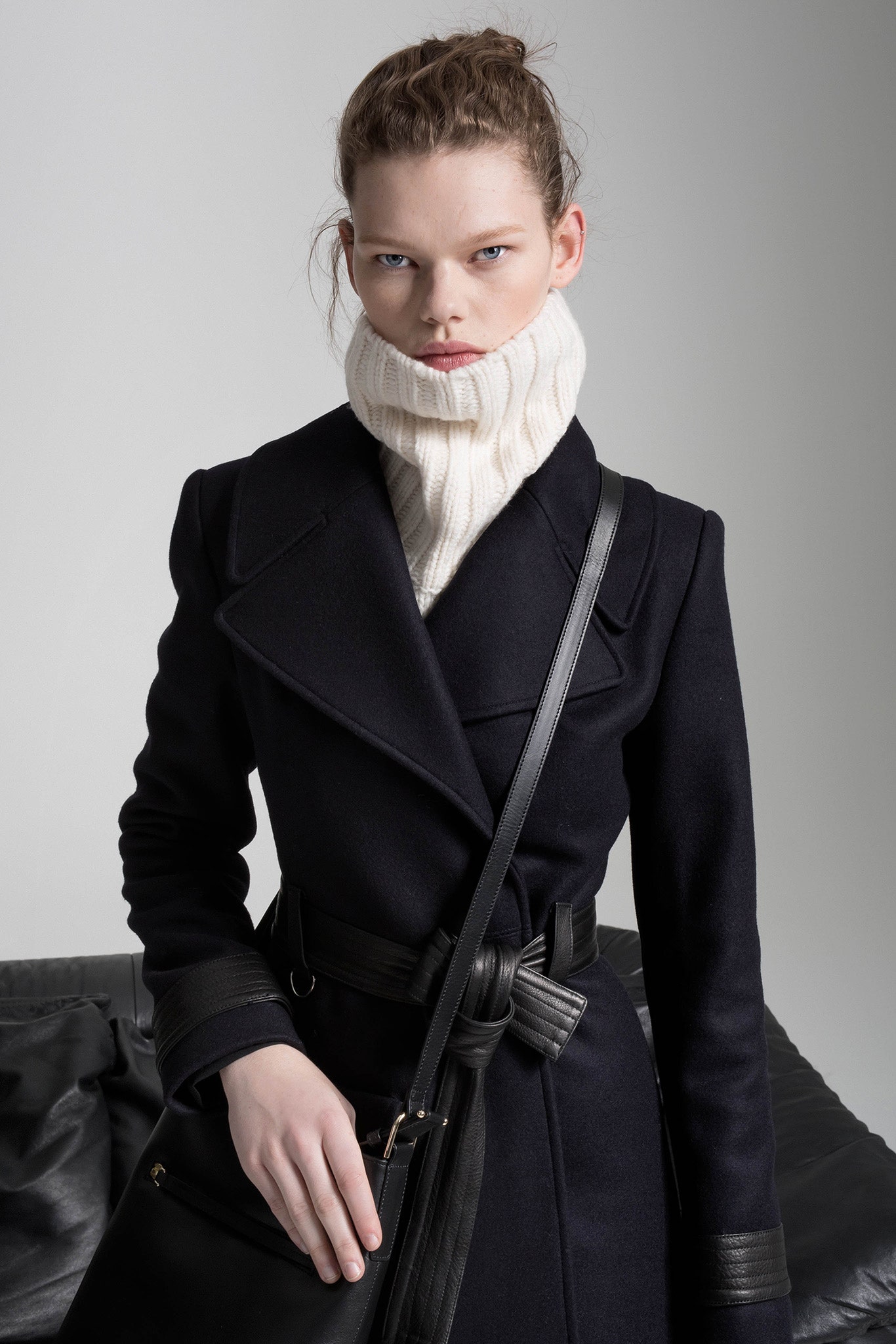 black wool fitted coat with white knit scarf