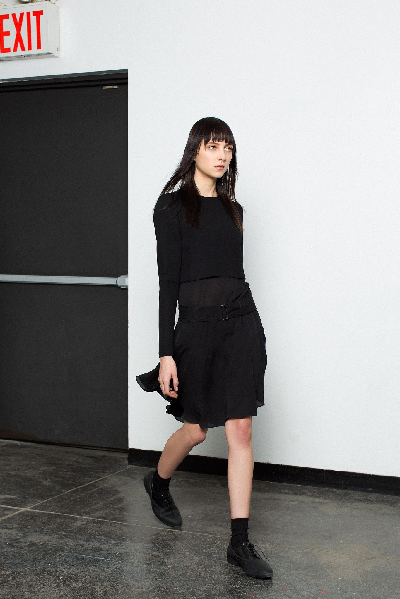 black fitted top and pleated mini skirt