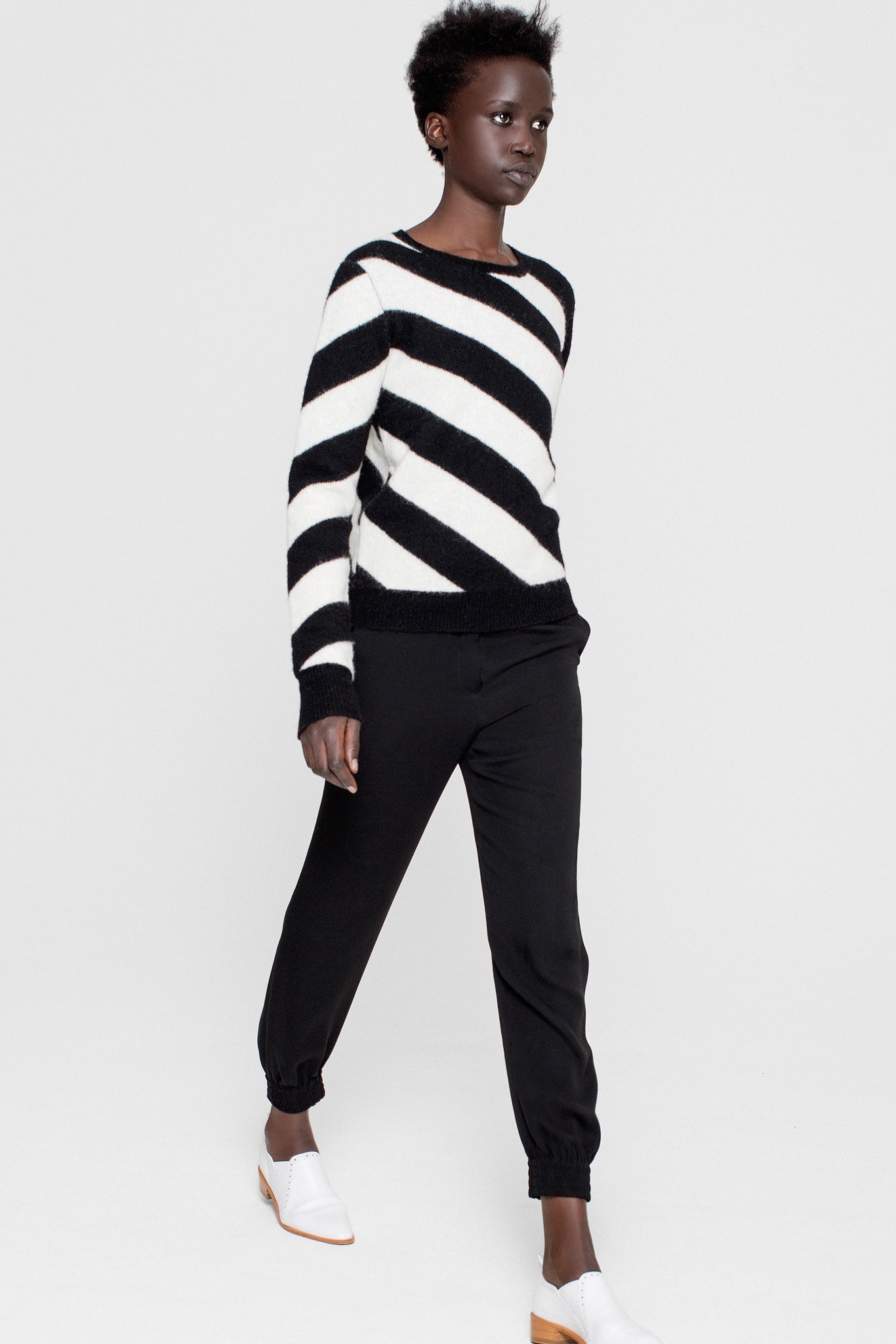 black and white striped sweater with black pants