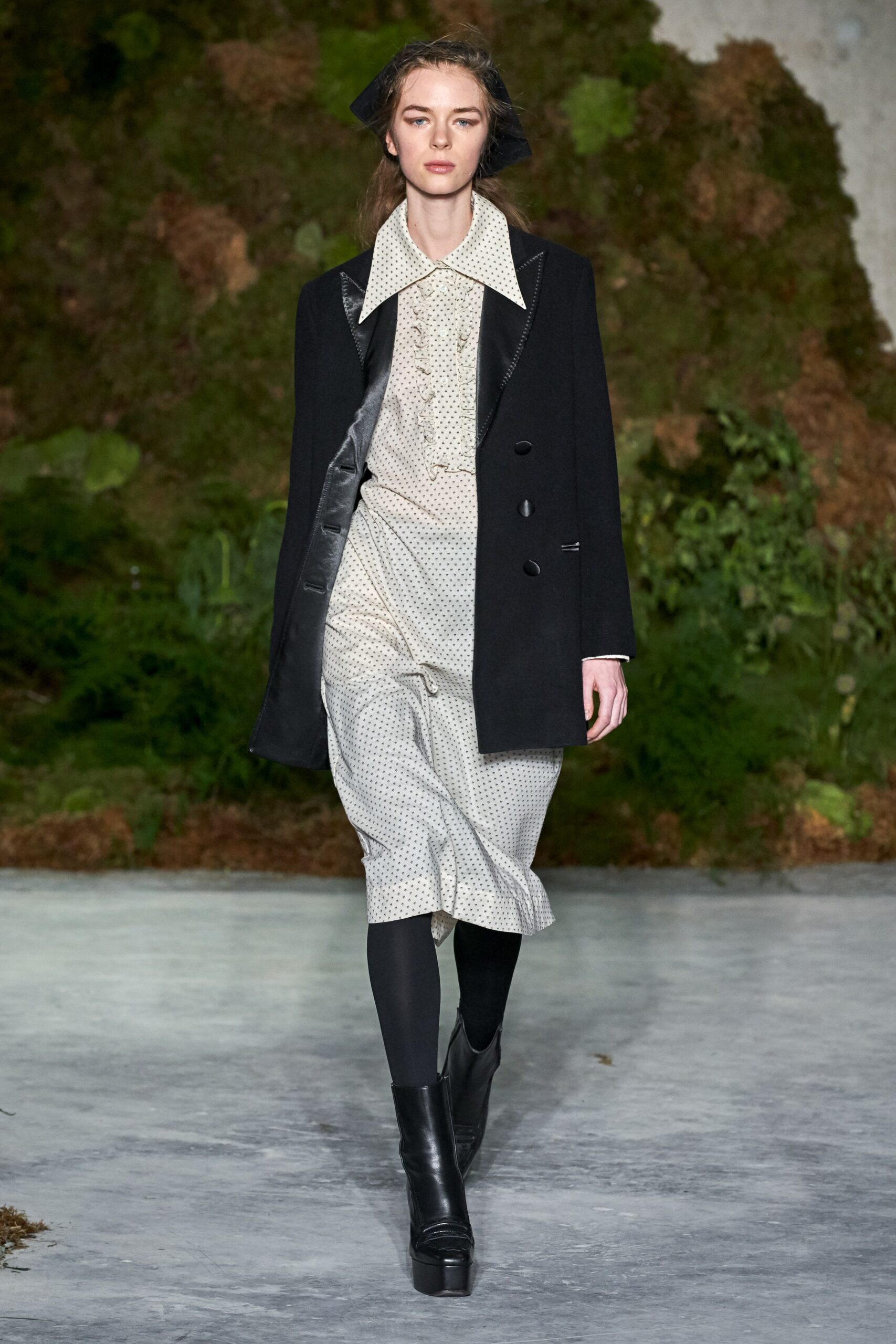 black tailored coat and white pleated dress