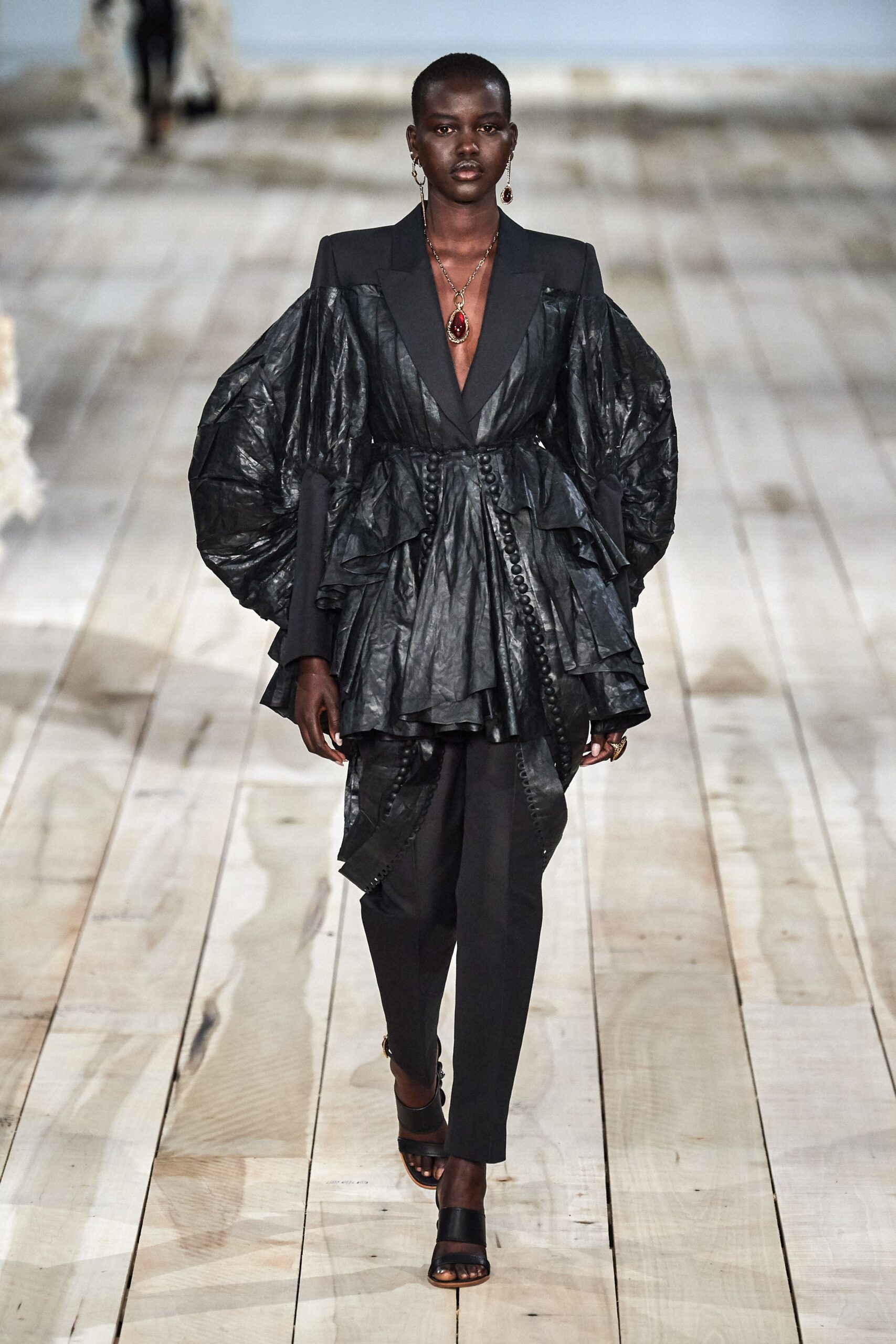 black ruffled blazer and tailored pants