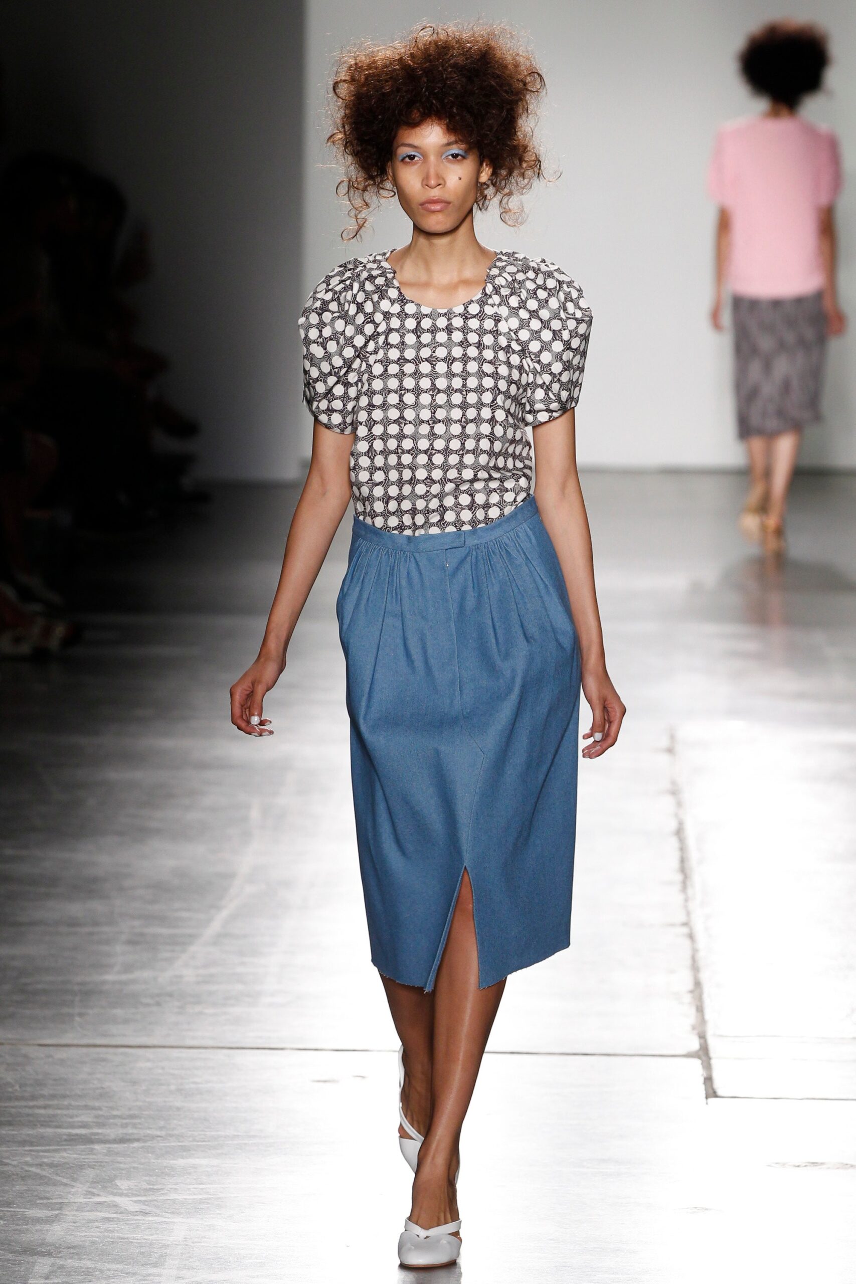 A fitted gray printed top paired with a high-waisted blue denim skirt featuring a slit.