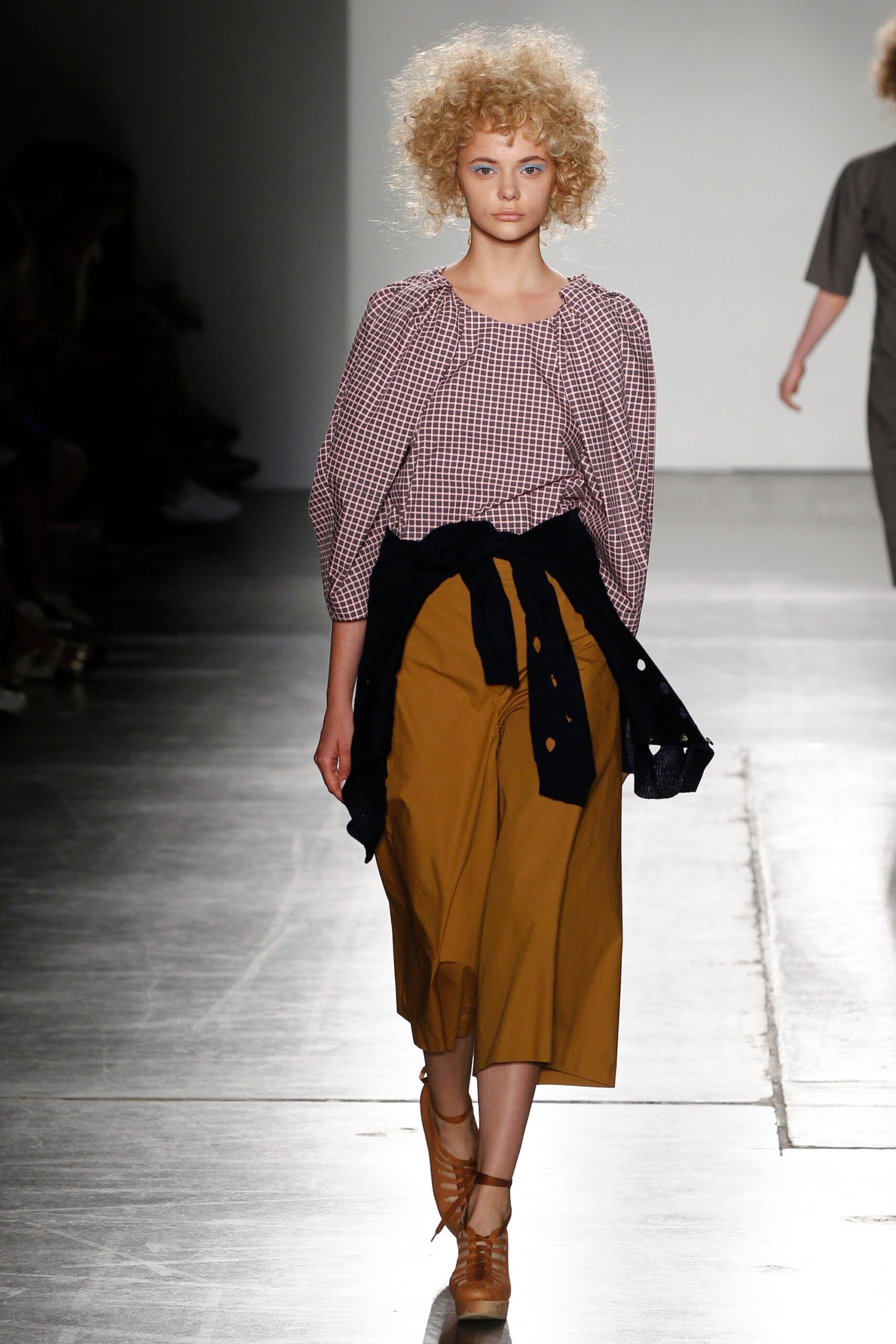 A relaxed long-sleeve checked top paired with brown culottes for a stylish look.
