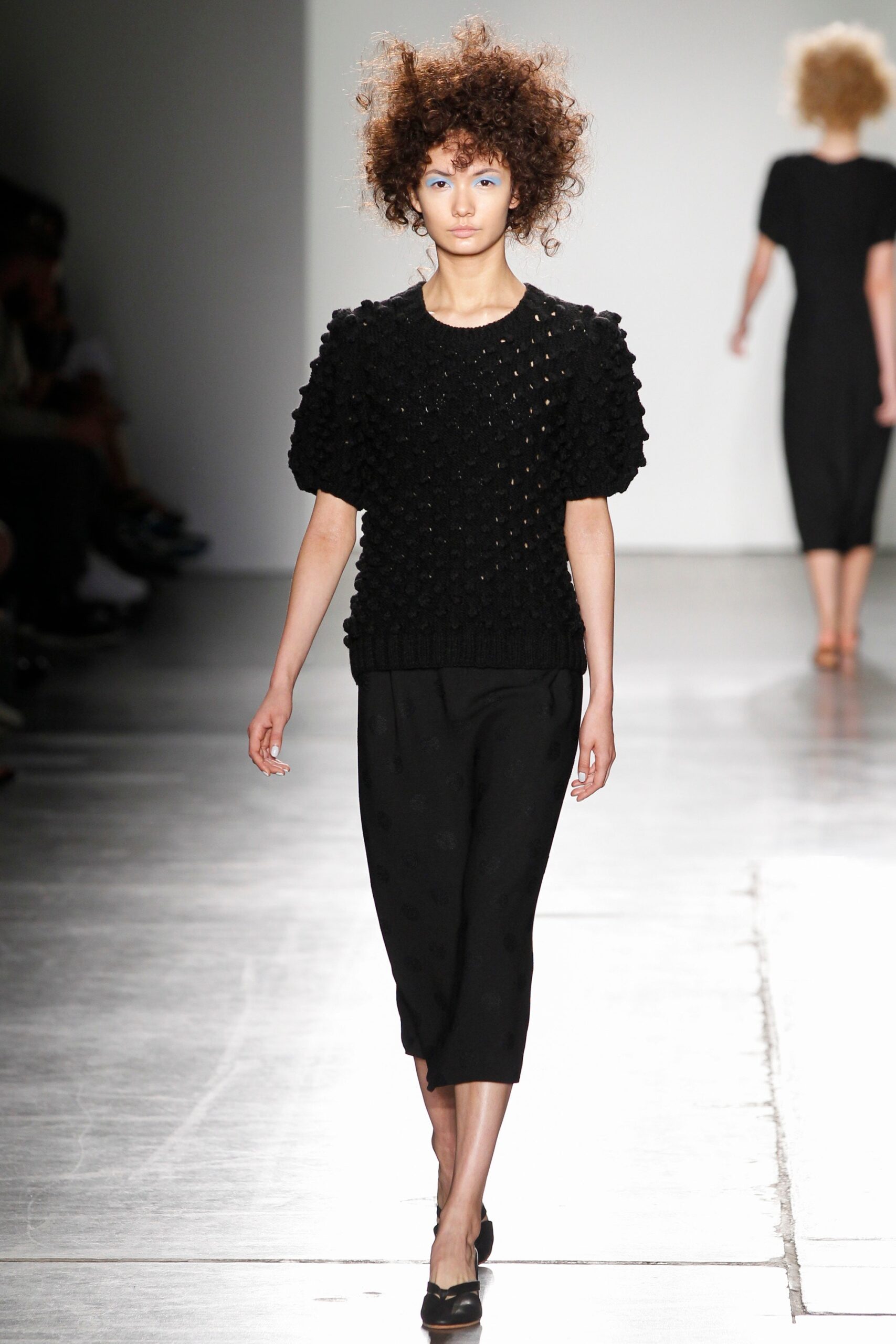 A fitted black cotton top with short sleeves and a textured pencil skirt.