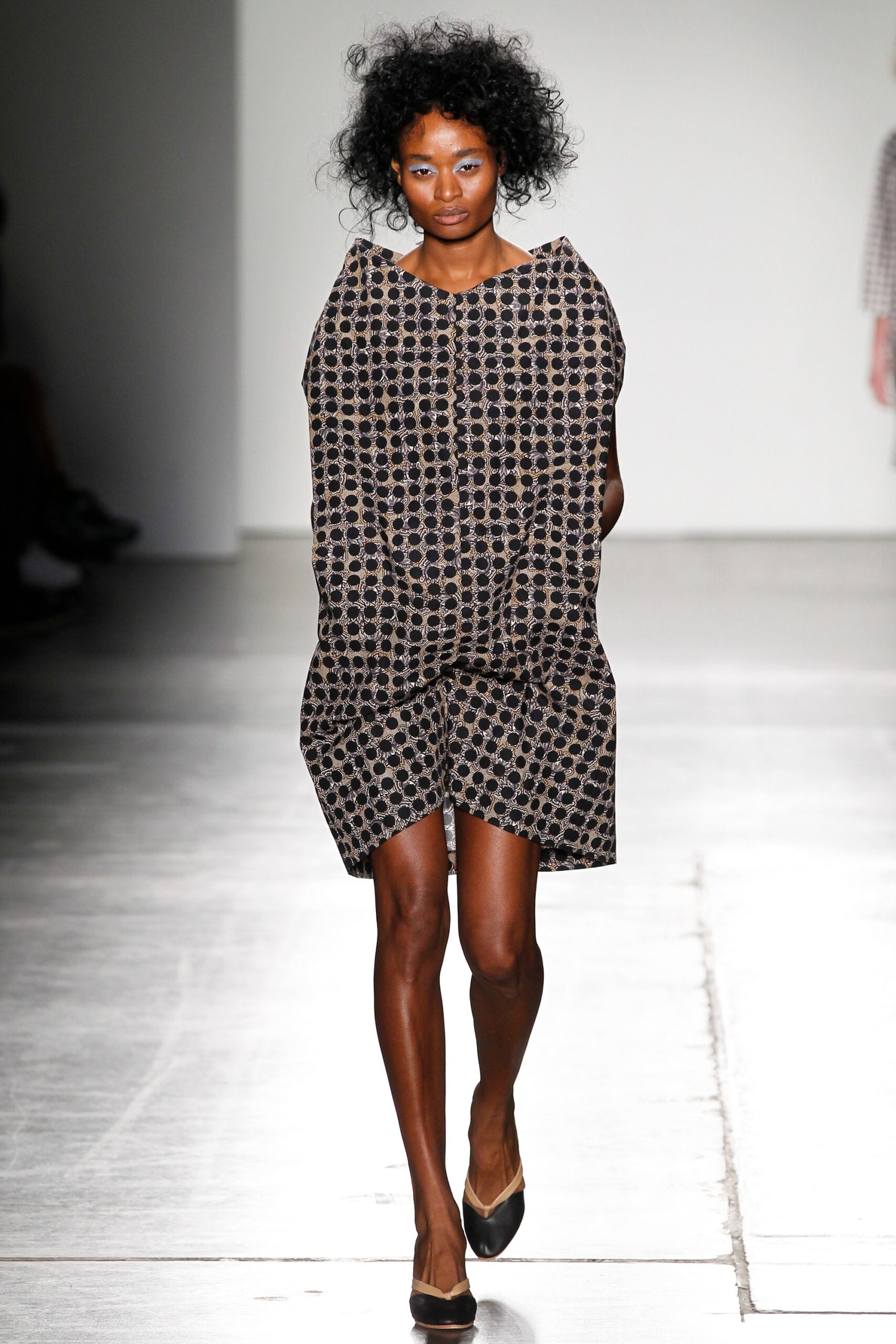A relaxed black dress with a printed pattern and sleeveless design featuring a collared neckline.