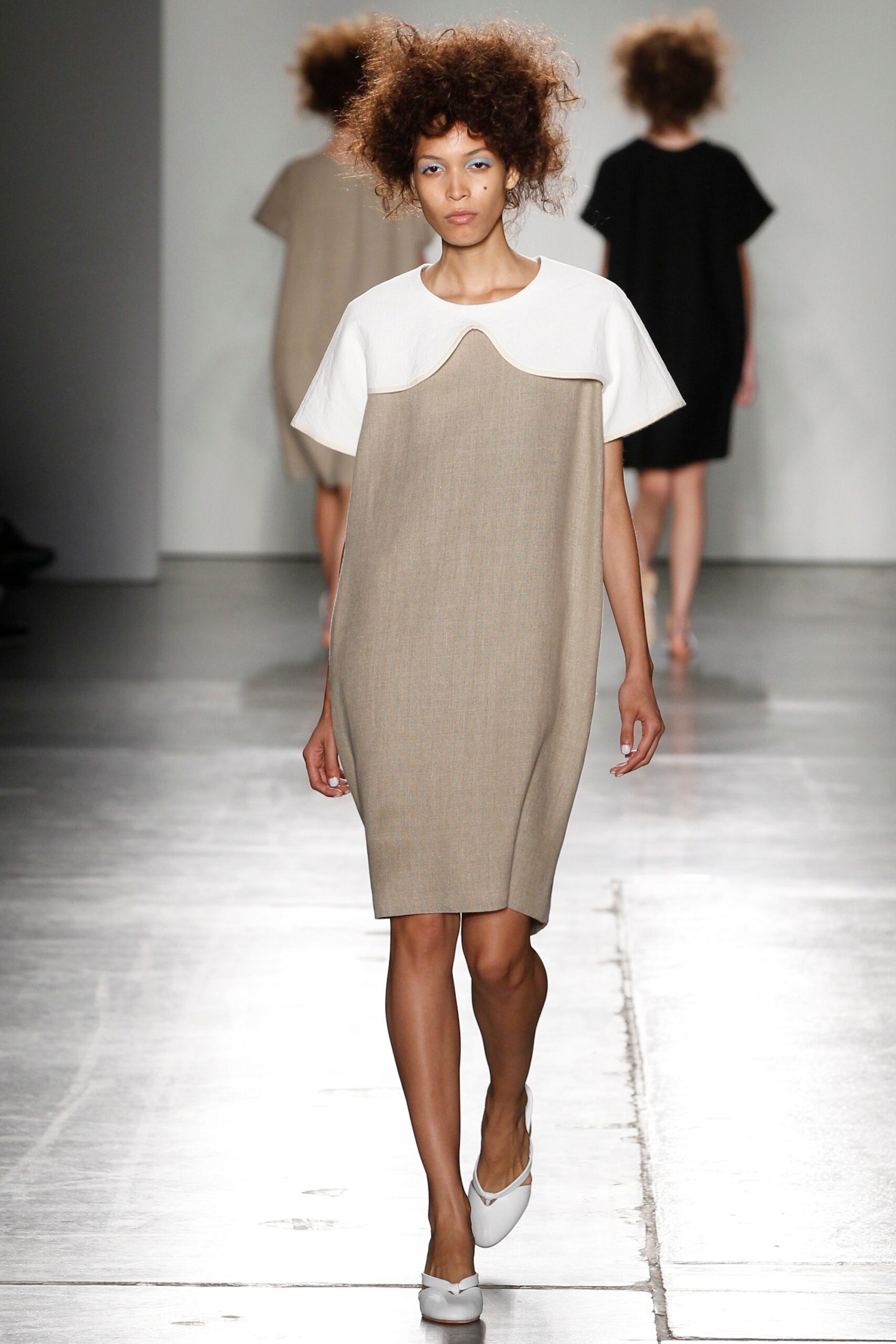 A relaxed beige and white dress with short sleeves and an asymmetric design detail.
