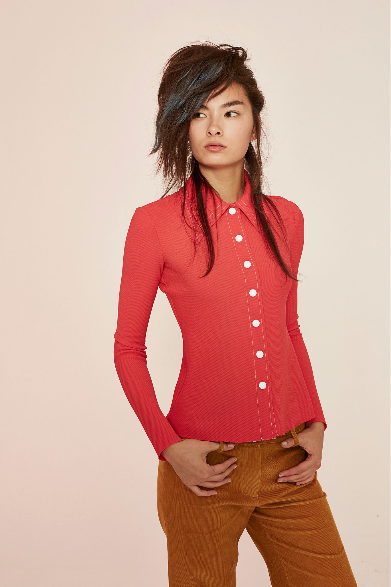 fitted red shirt and relaxed brown pants