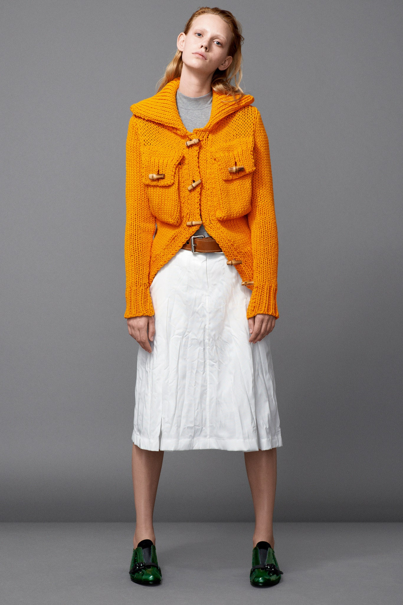 orange cardigan white pleated skirt