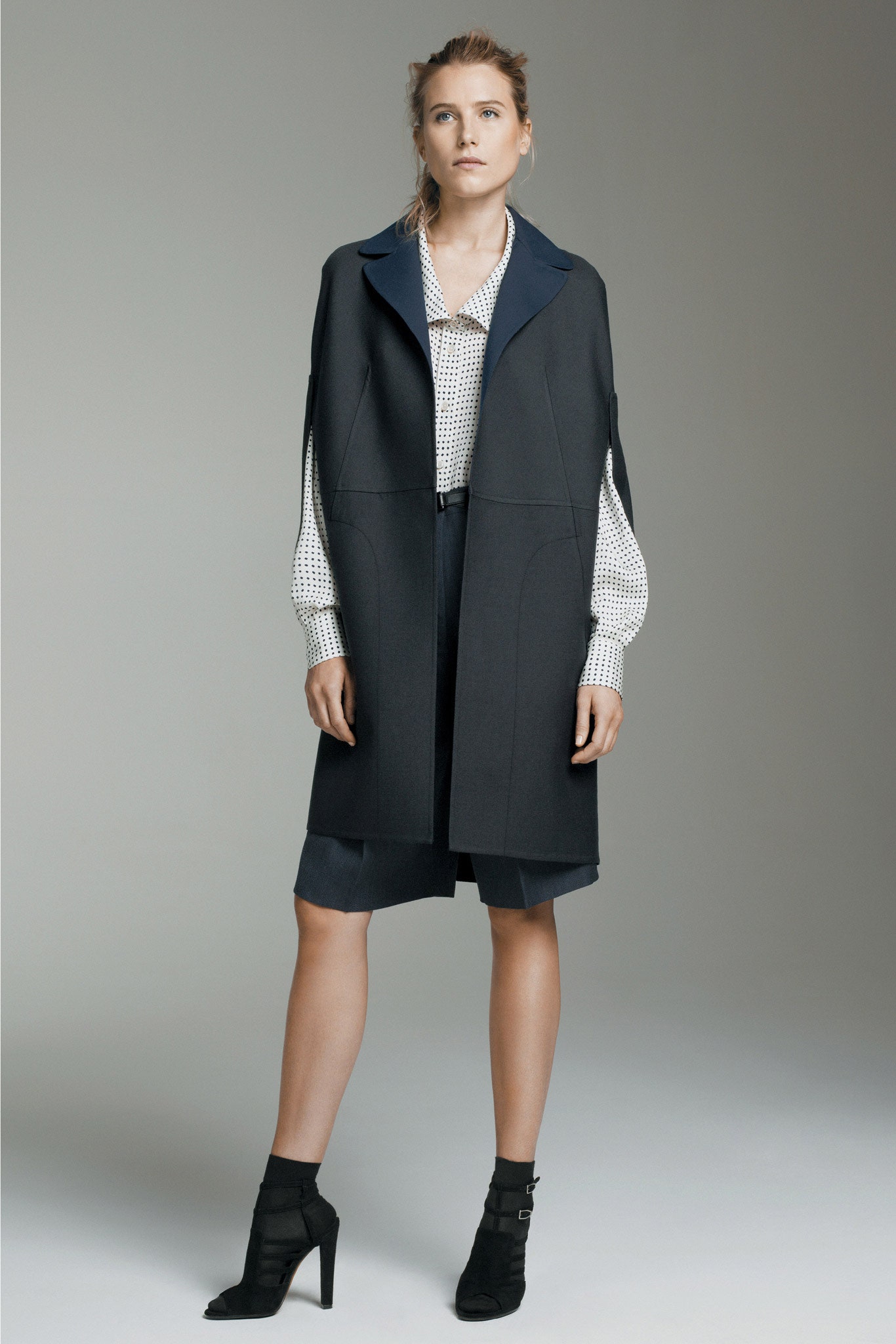 black wool coat with polka-dot blouse