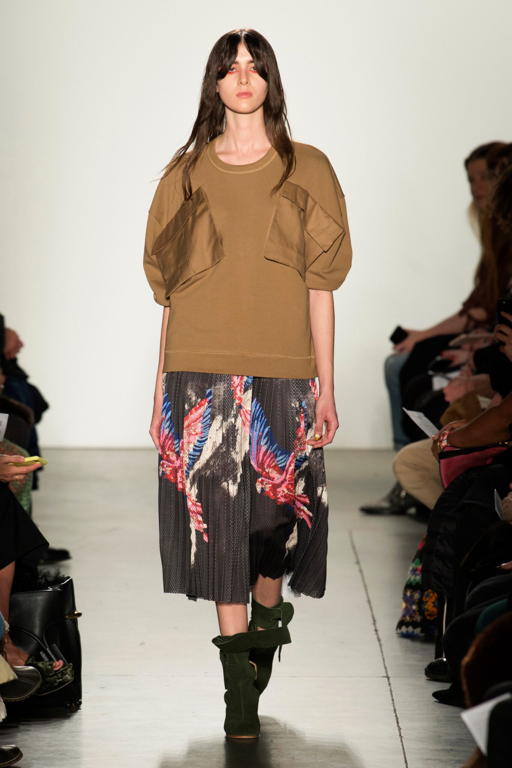 A relaxed brown top paired with a high-waisted pleated skirt featuring a multicolor design.